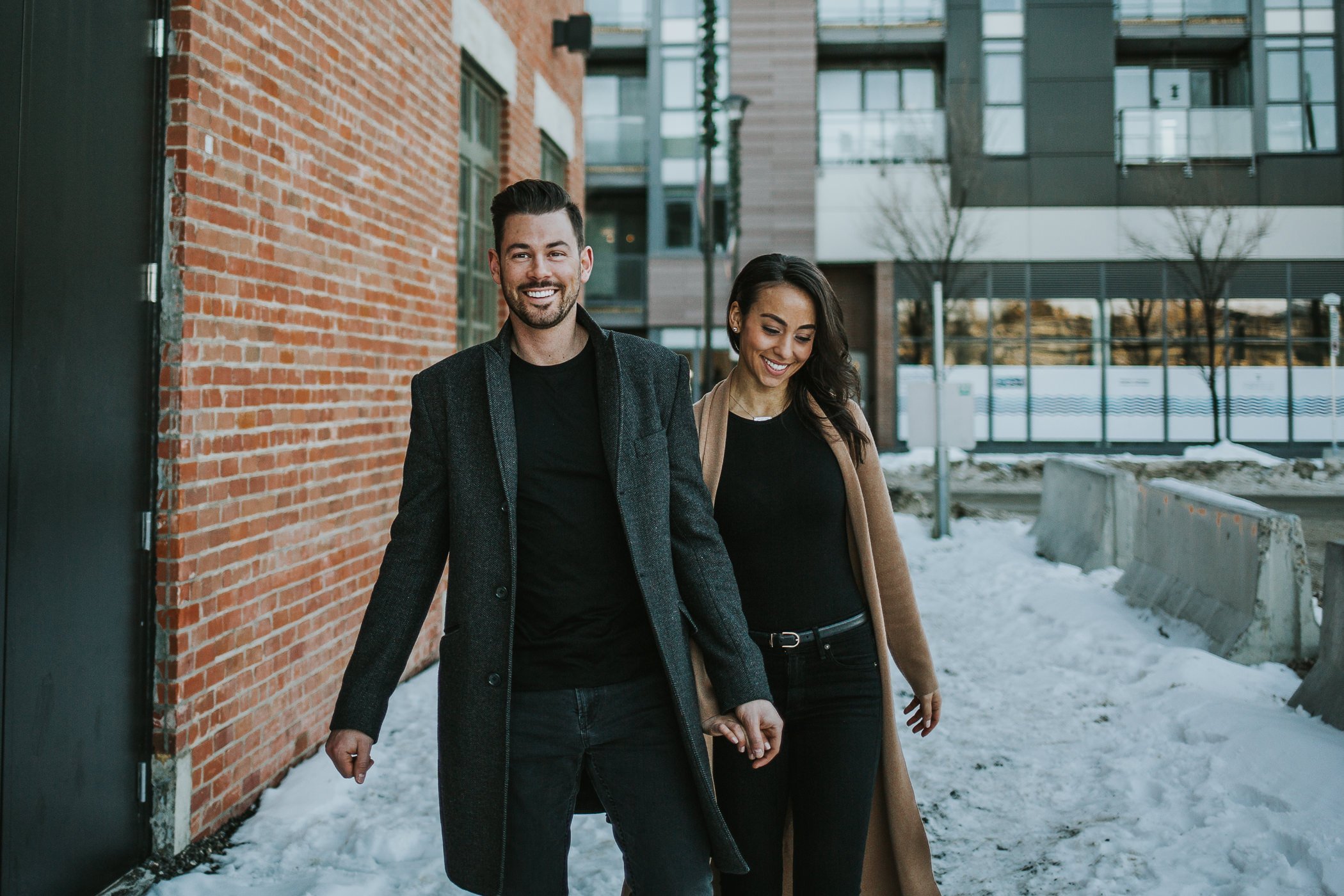 Couple walking through they alley in the snow in Calgary 