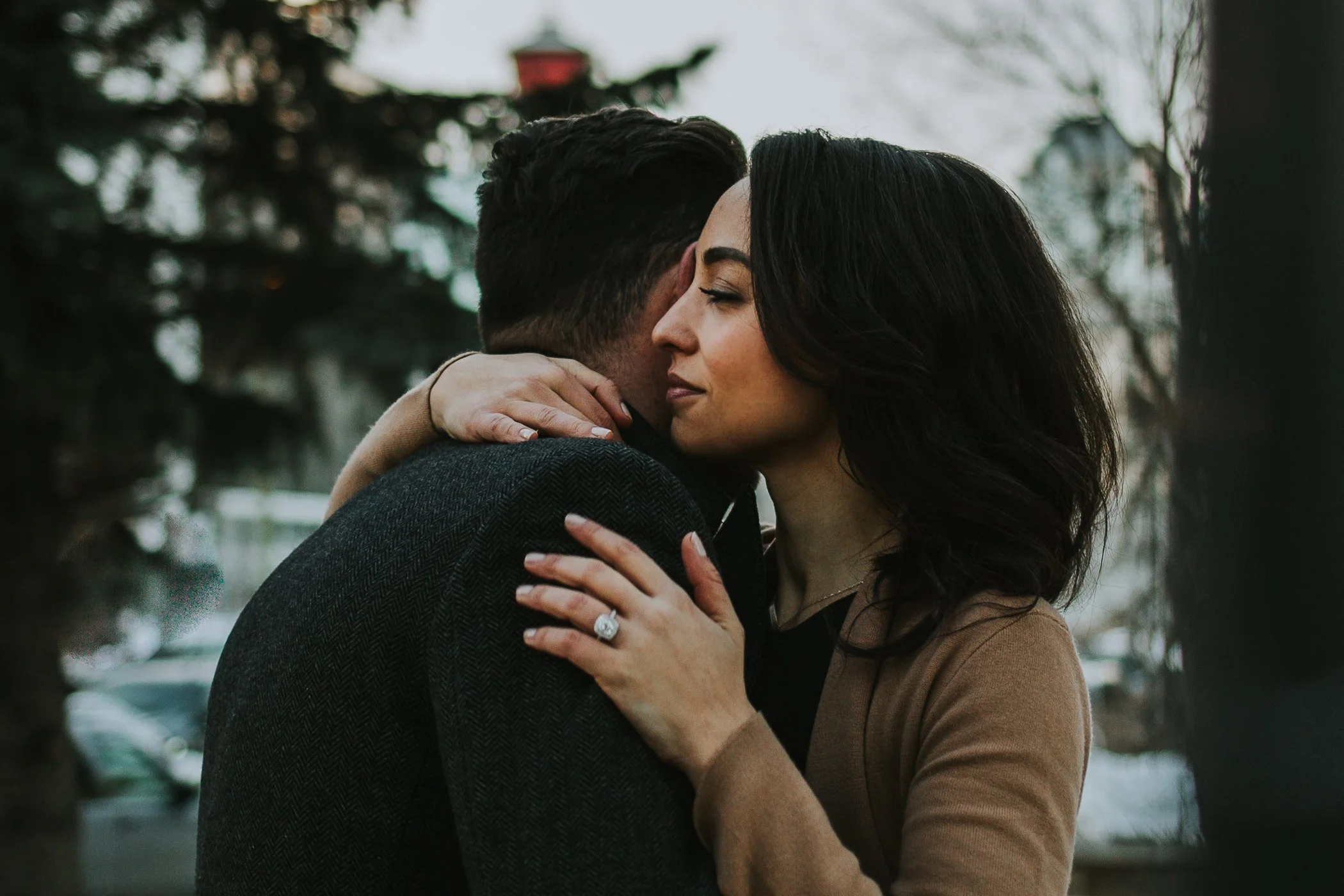 Couple hugging in front of a tree
