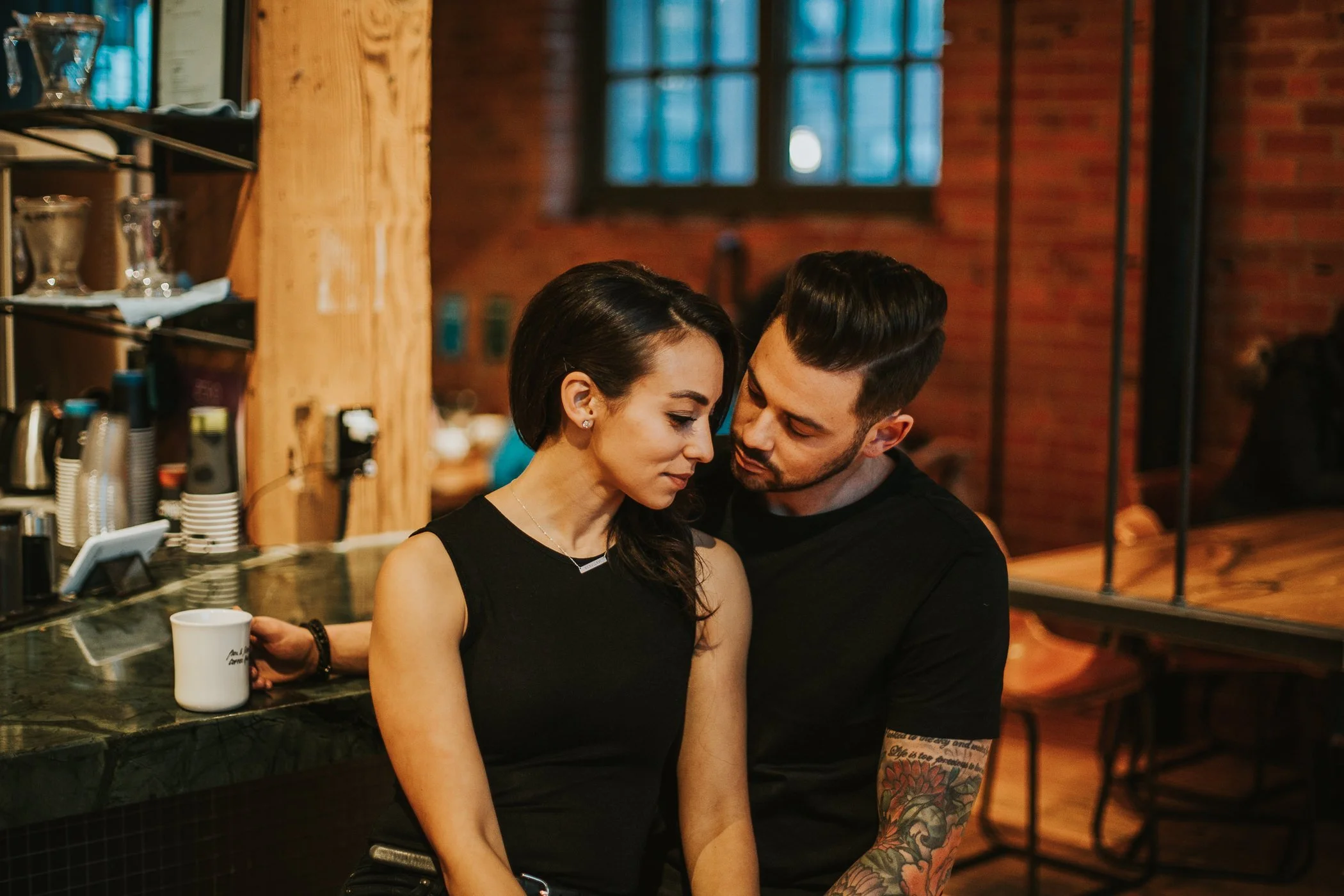 Couple enjoying coffee in brick walled coffee shop in Calgary 
