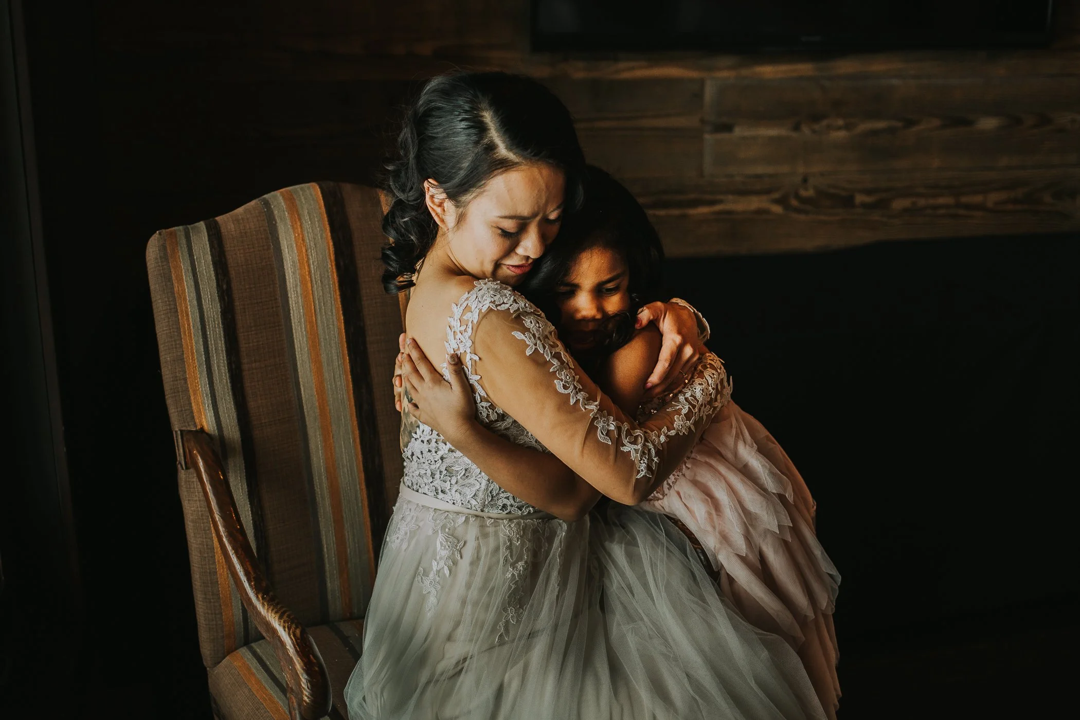 Bride hugging flower girl moody winter wedding 