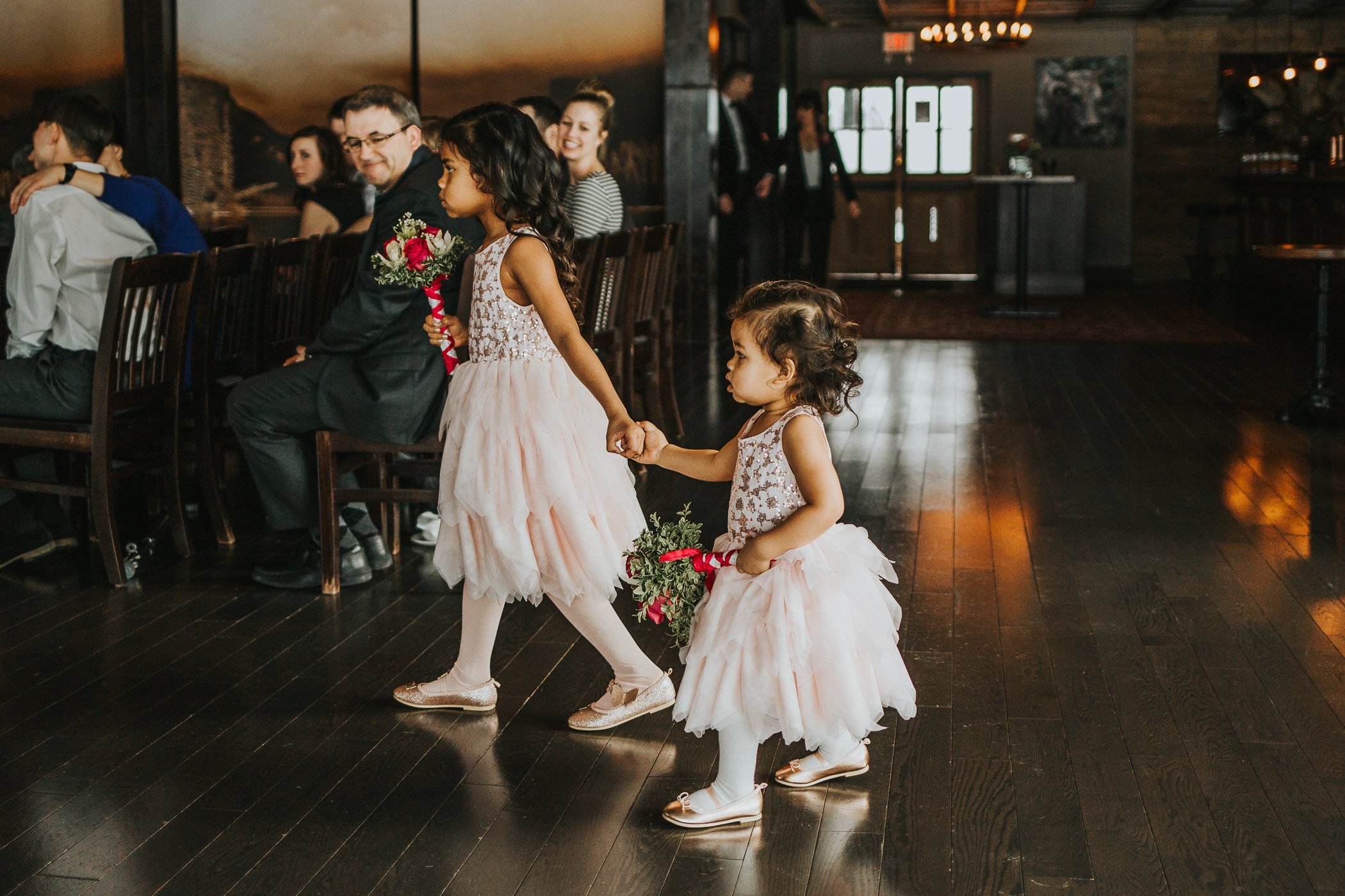 Flower girls walking down the aisle at Calgary Alberta winter wedding