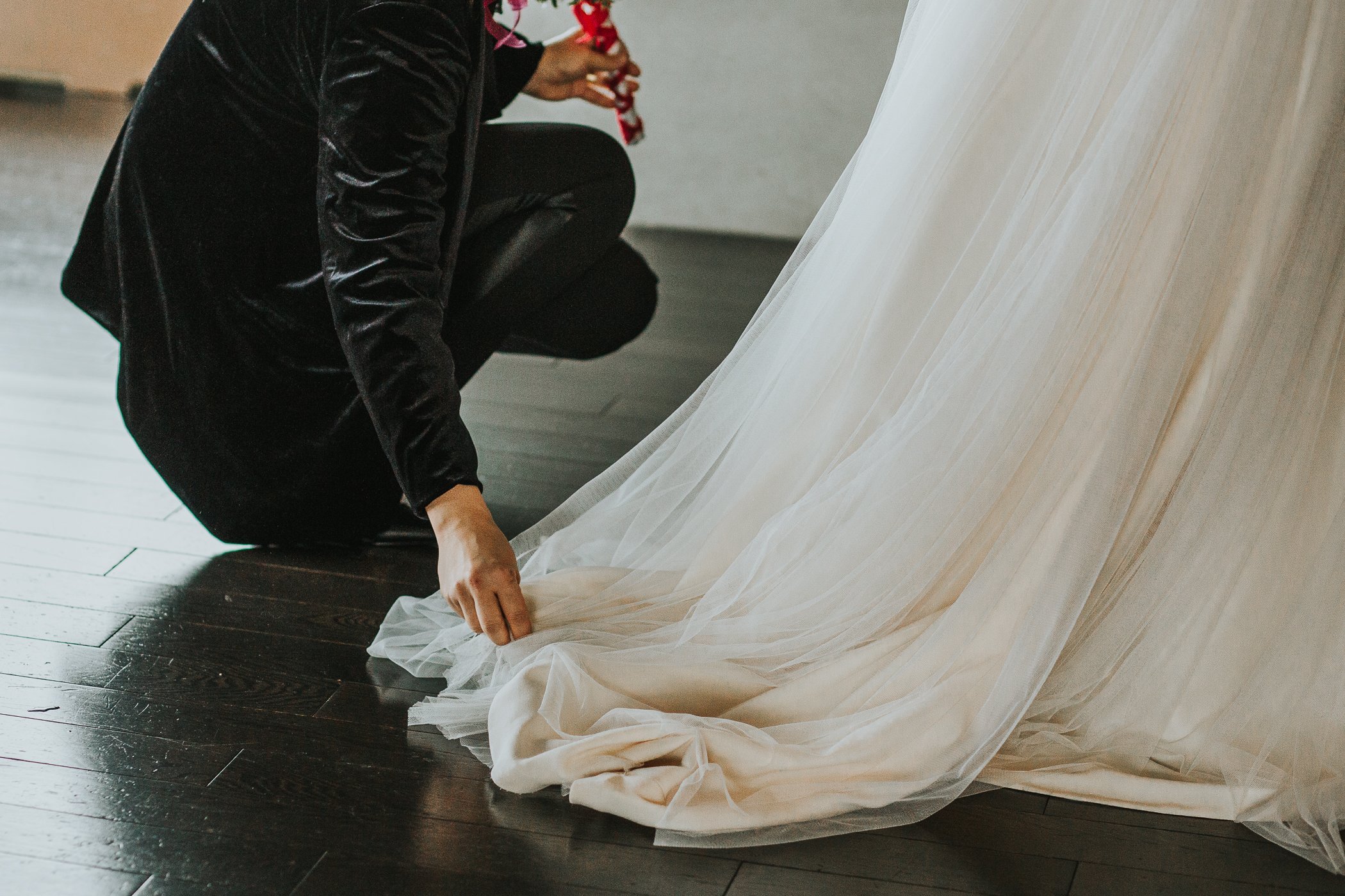 Bridesmaid fixing brides dress at Calgary Alberta winter wedding