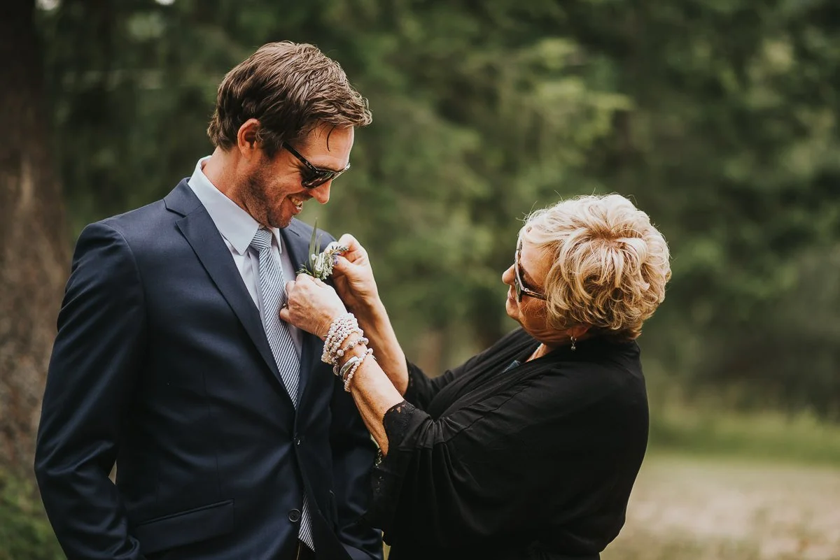 Alberta ranch wedding groom and mom putting on boutonniere