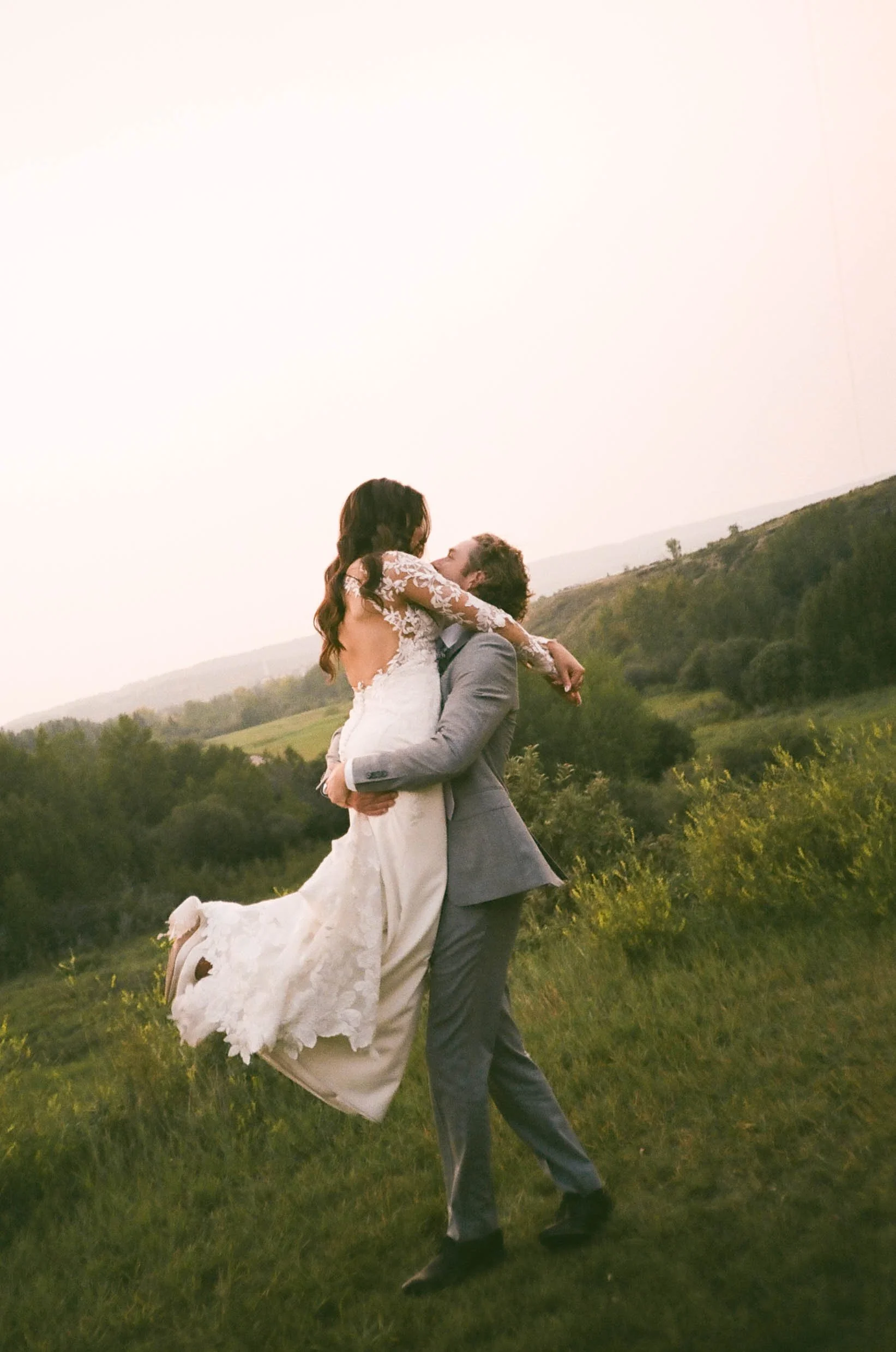 Film photo of couple hugging outside their wedding reception at cochrane Ranche House 