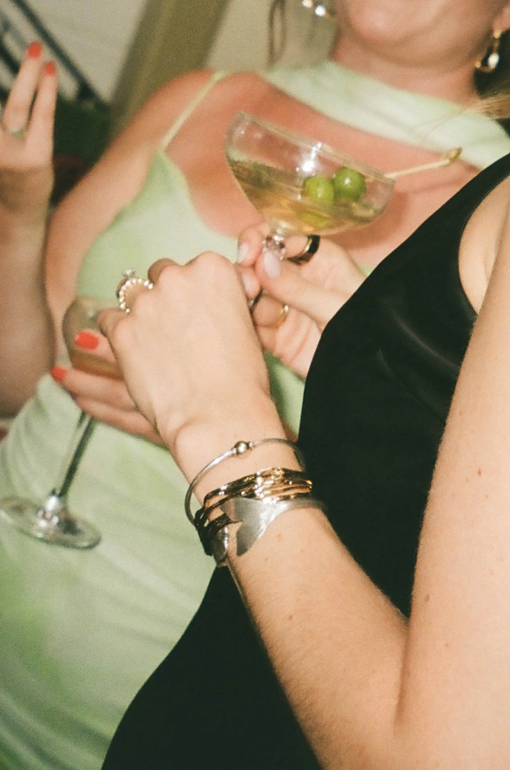 Film photo of woman in green dress holding a martini glass at wedding at Lupo restaurant in Banff