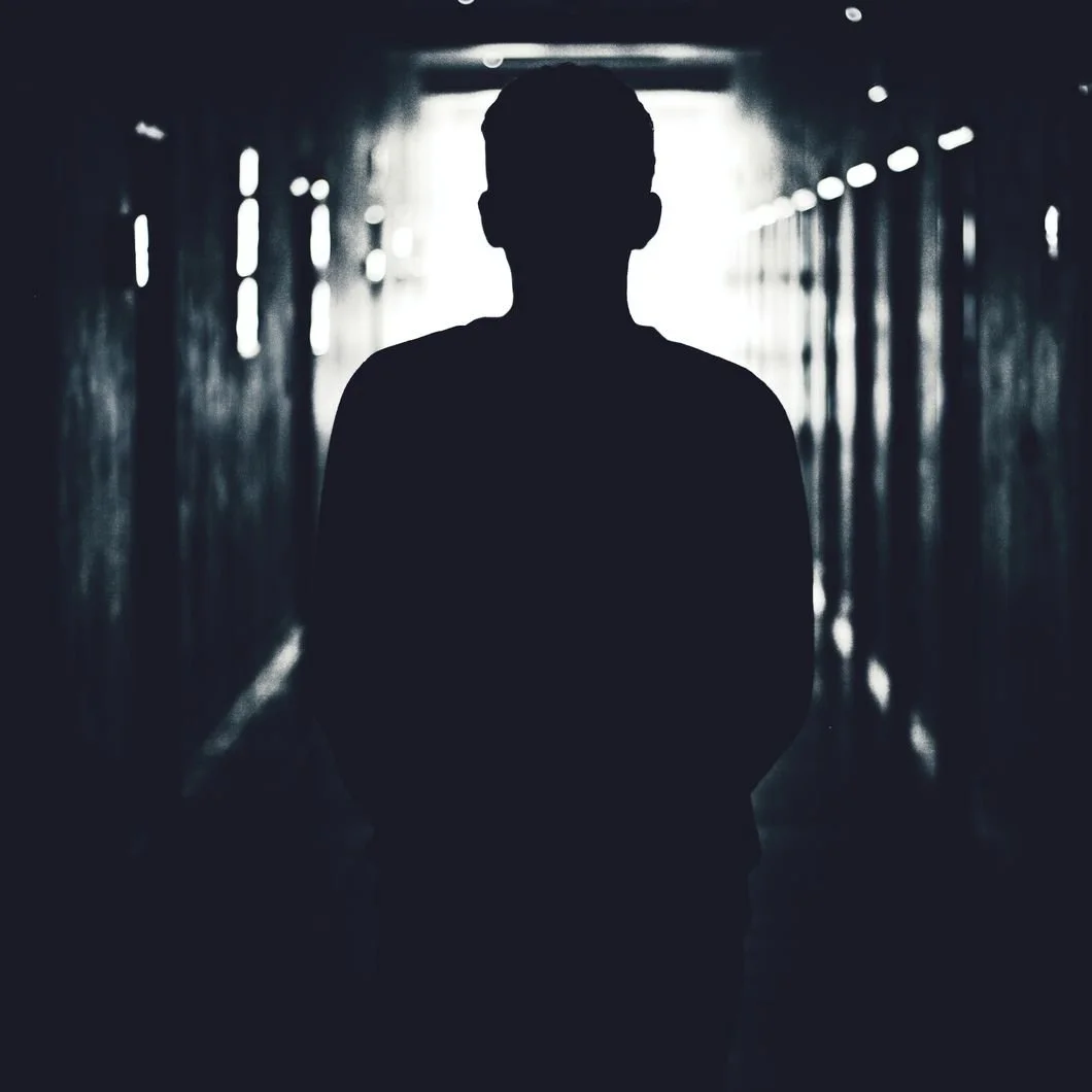 Silhouetted figure standing in a dark fluorescent-lit corridor, representing a career shaped by retail management, operations, culture, and leadership pressure.