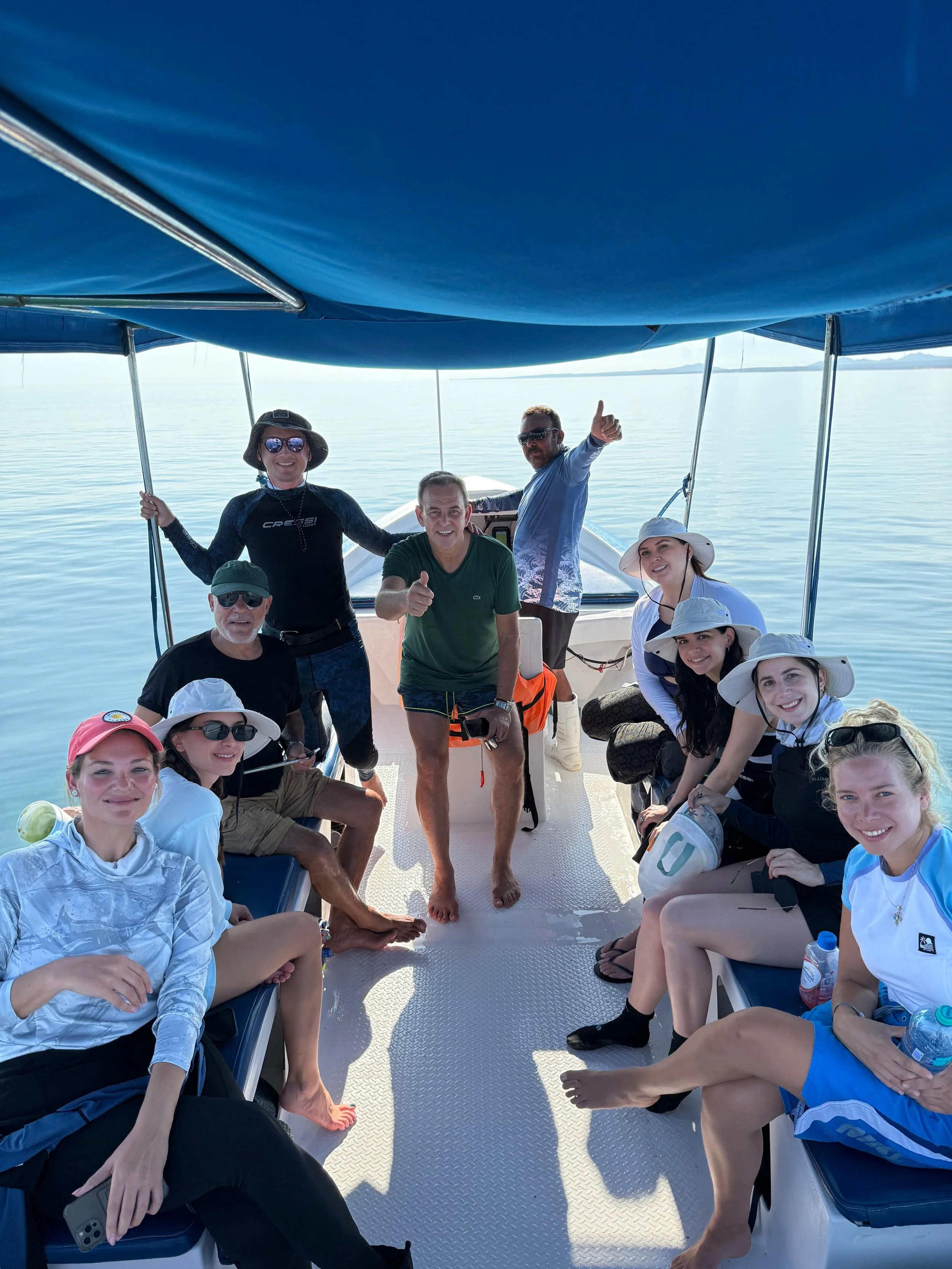 Grupo de personas en una panga en el Mar de Cortez, algunos con sombreros y gafas, todos sonriendo y disfrutando el tour de snorkel en La Ventana, BCS. Bajablue tours