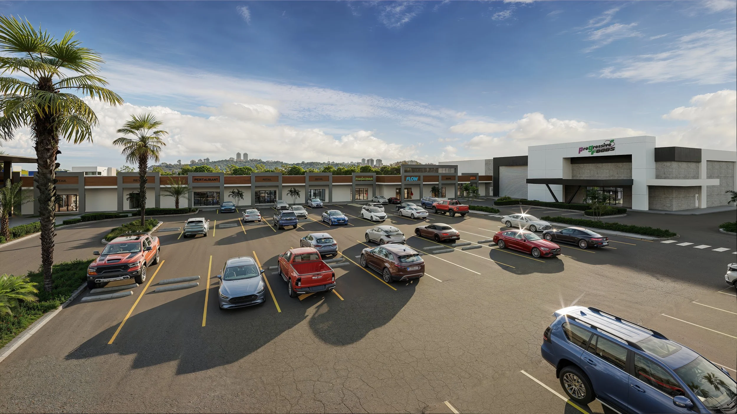 Shopping center parking lot with multiple cars parked near stores, including a larger retail store with a sign that reads 'Progressive Foods'. Palm trees are visible along the lot and a backdrop of hills and city skyline under a partly cloudy sky.