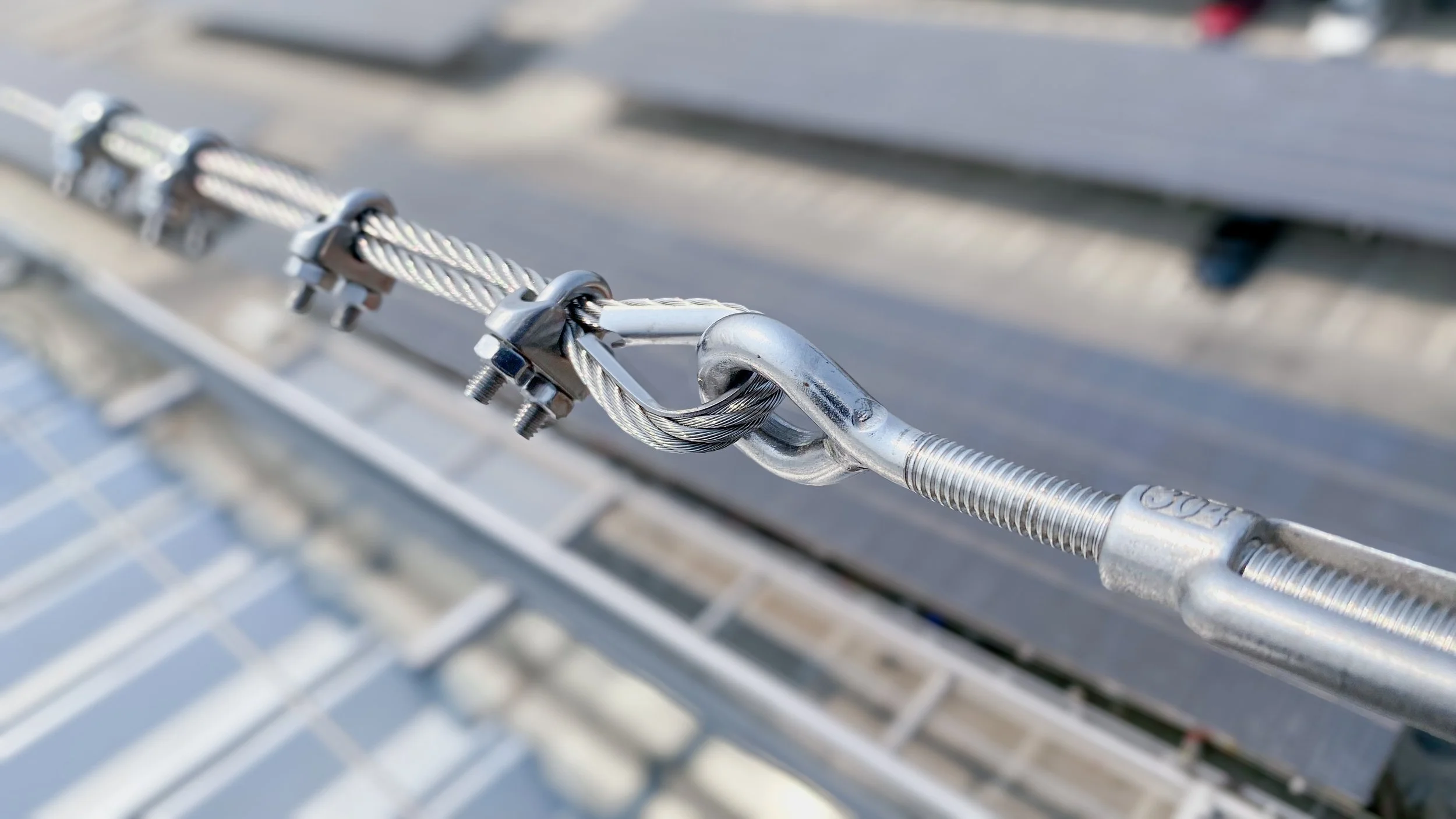 Close-up of a metal cable with a shackle and clamps