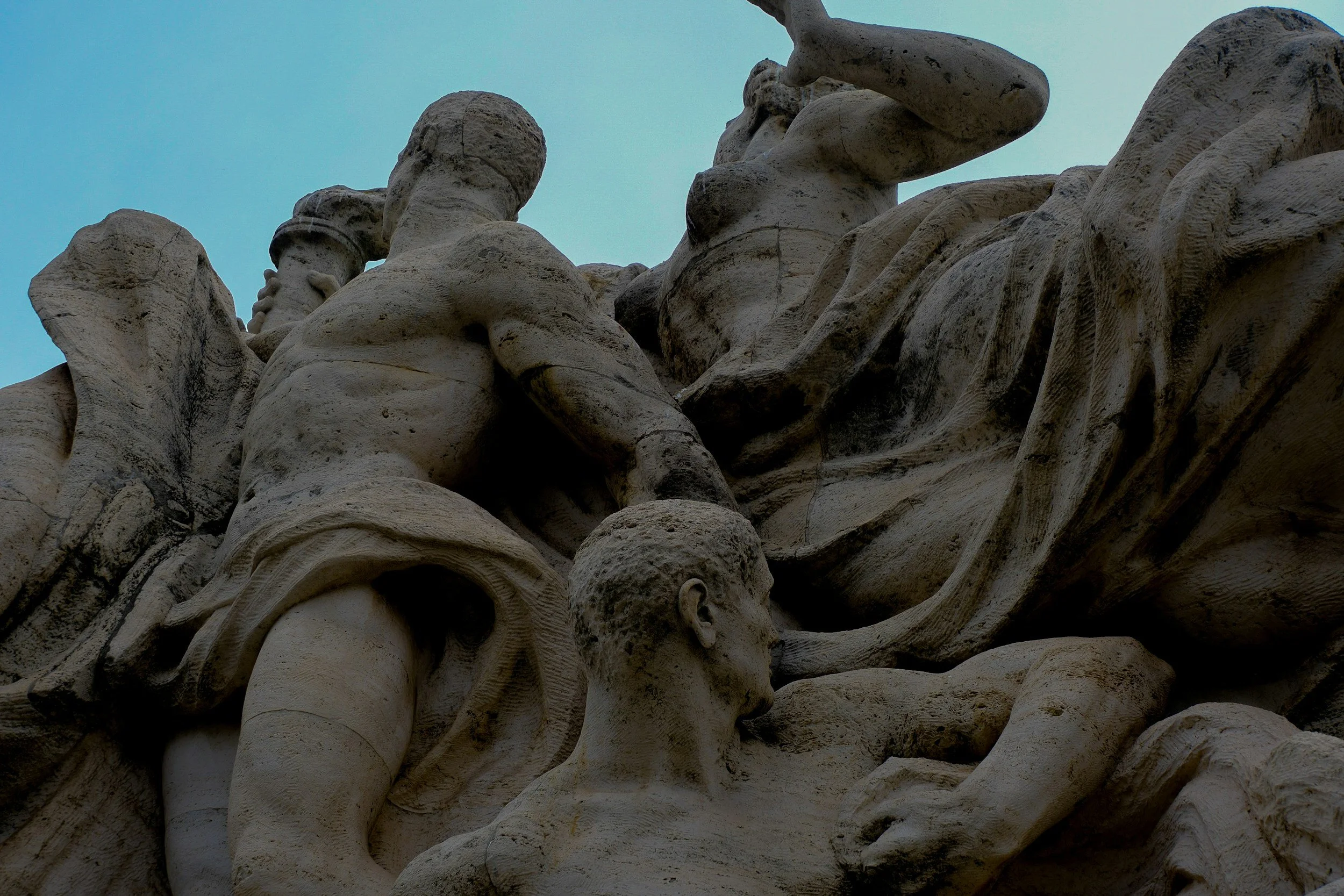 Détail d'une sculpture en pierre représentant plusieurs figures humaines.