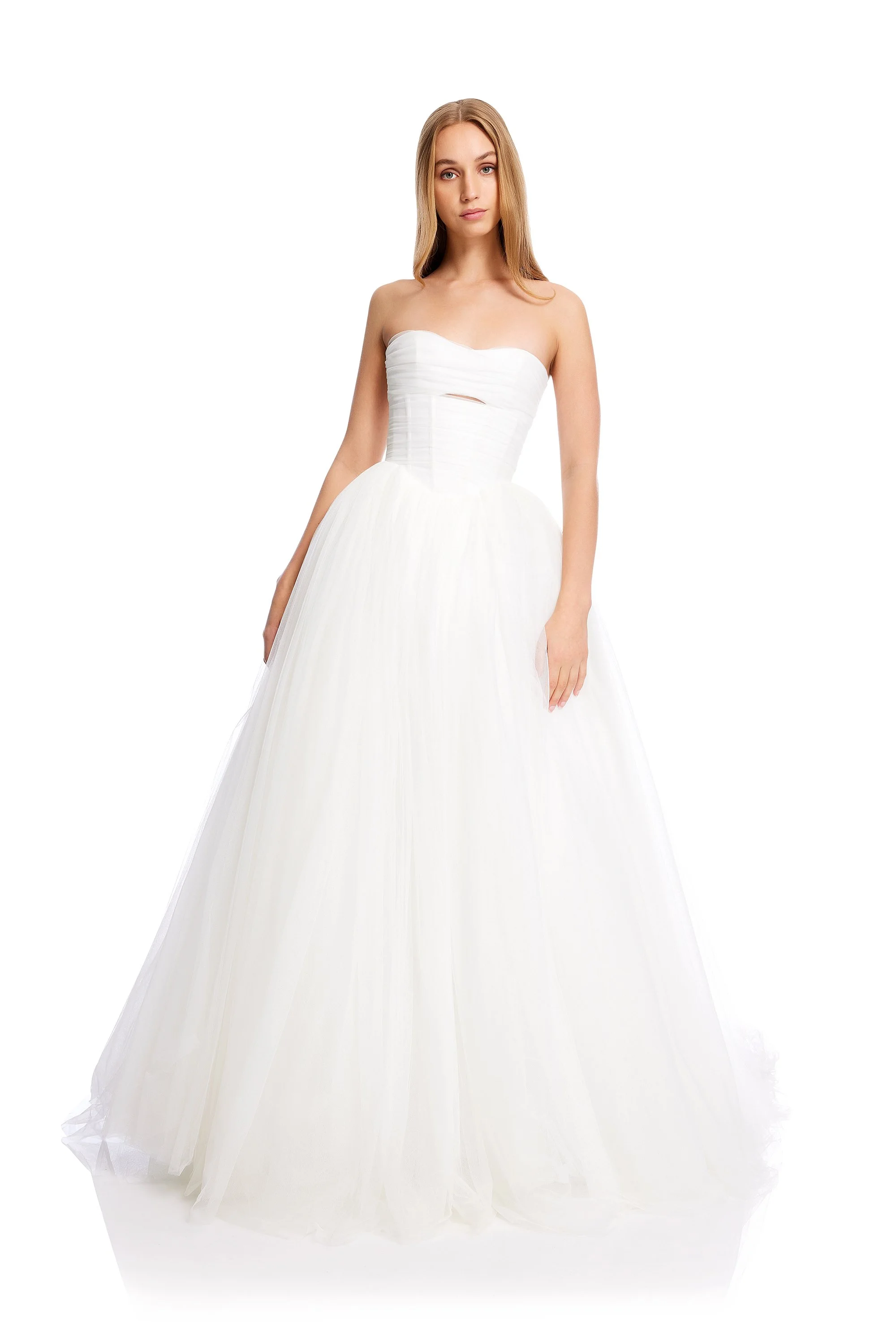 A young woman in a strapless white wedding dress with a fitted bodice and full skirt, standing against a plain white background.