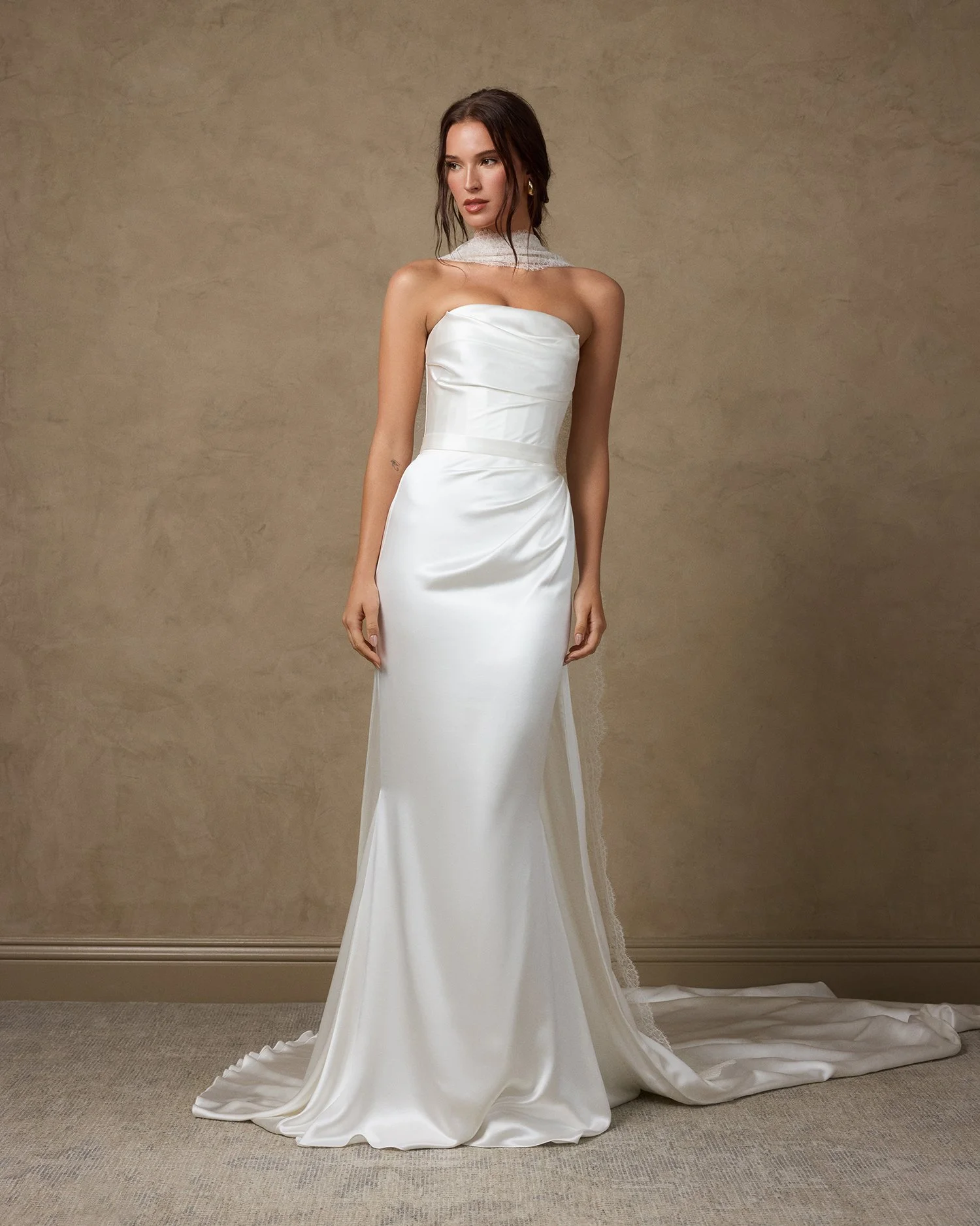 Woman in a white satin wedding dress with a lace veil.