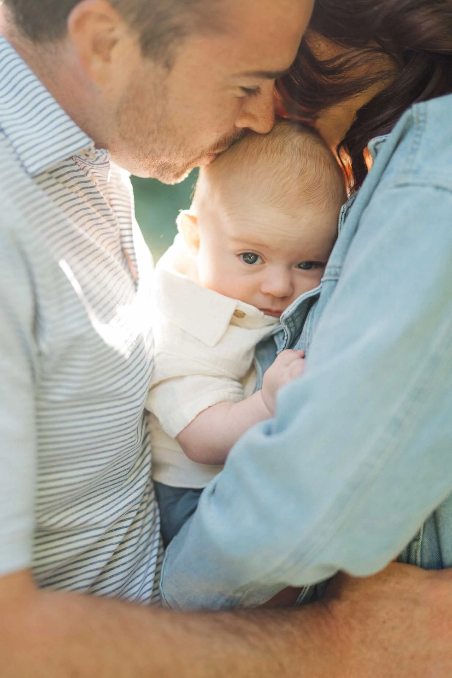 Close-up of a baby being held between both parents during a tender family photography moment in Raleigh, NC.