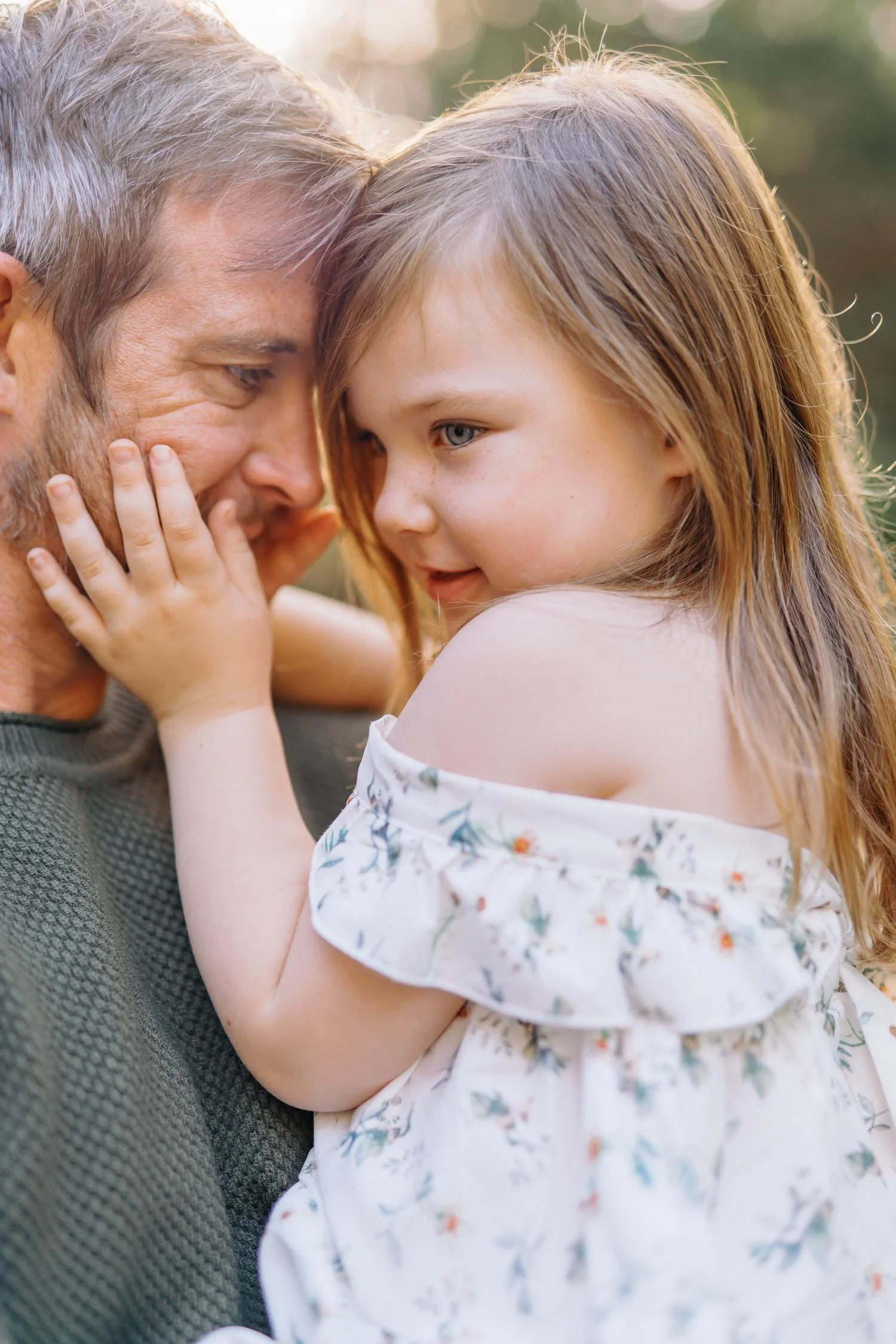 Father holding his toddler outside in the backyard during a signature family photography session in Raleigh, NC.