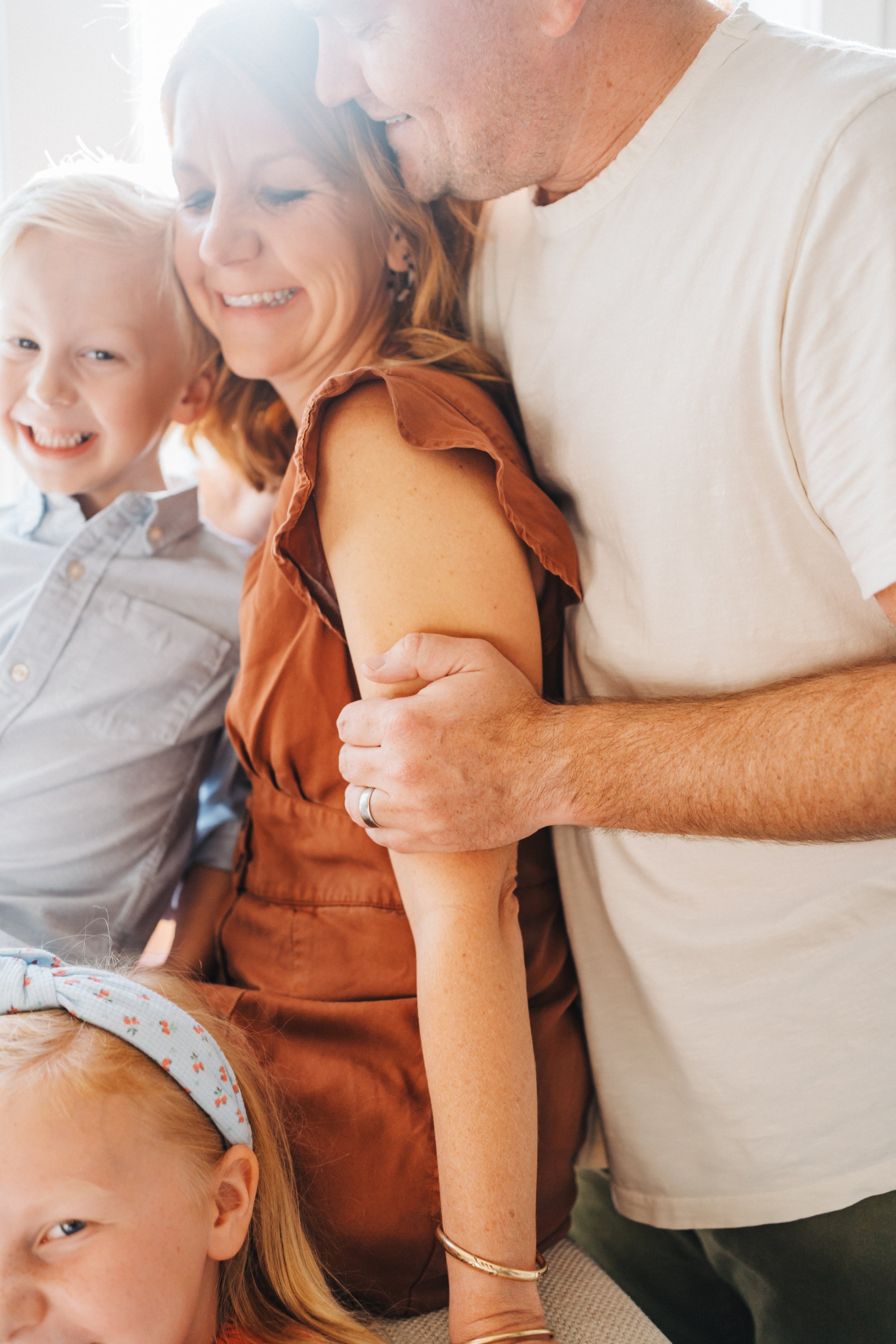 Raleigh Family Photographer Mom and Dad Cuddling and Smiling with Son 