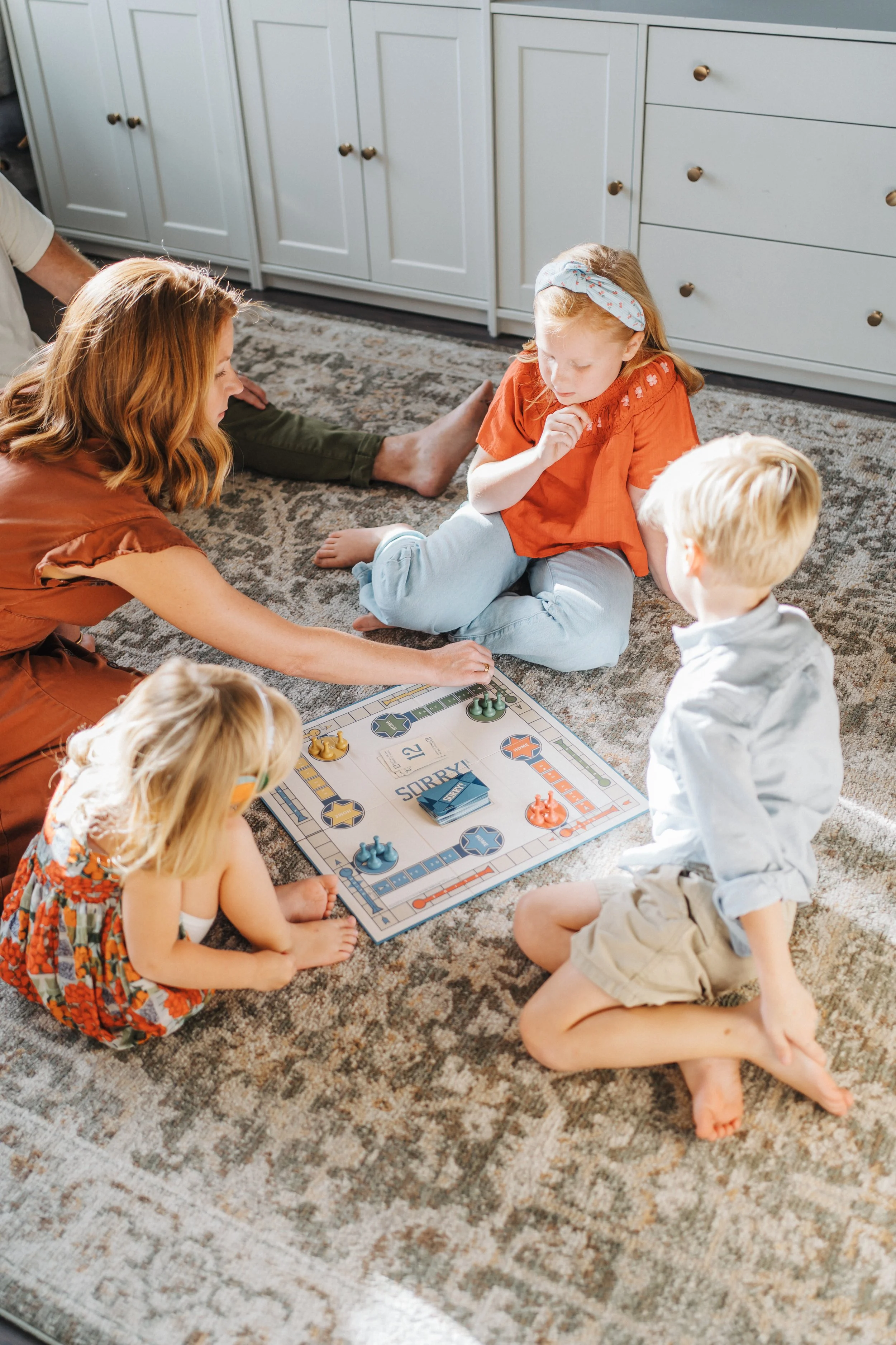 Raleigh, North Carolina Family of five playing board game in living room Raleigh family photography