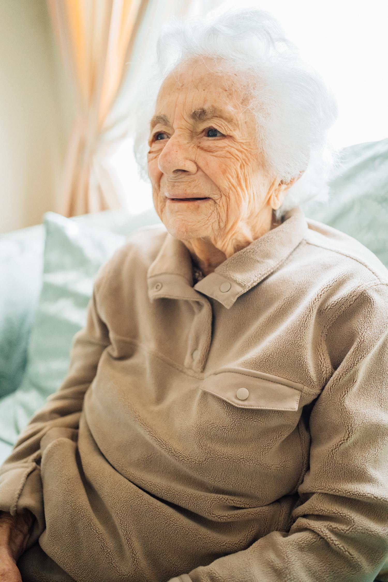 Close-up portrait of a grandmother sitting on the couch during a multi-generational family photography session in Raleigh, North Carolina.