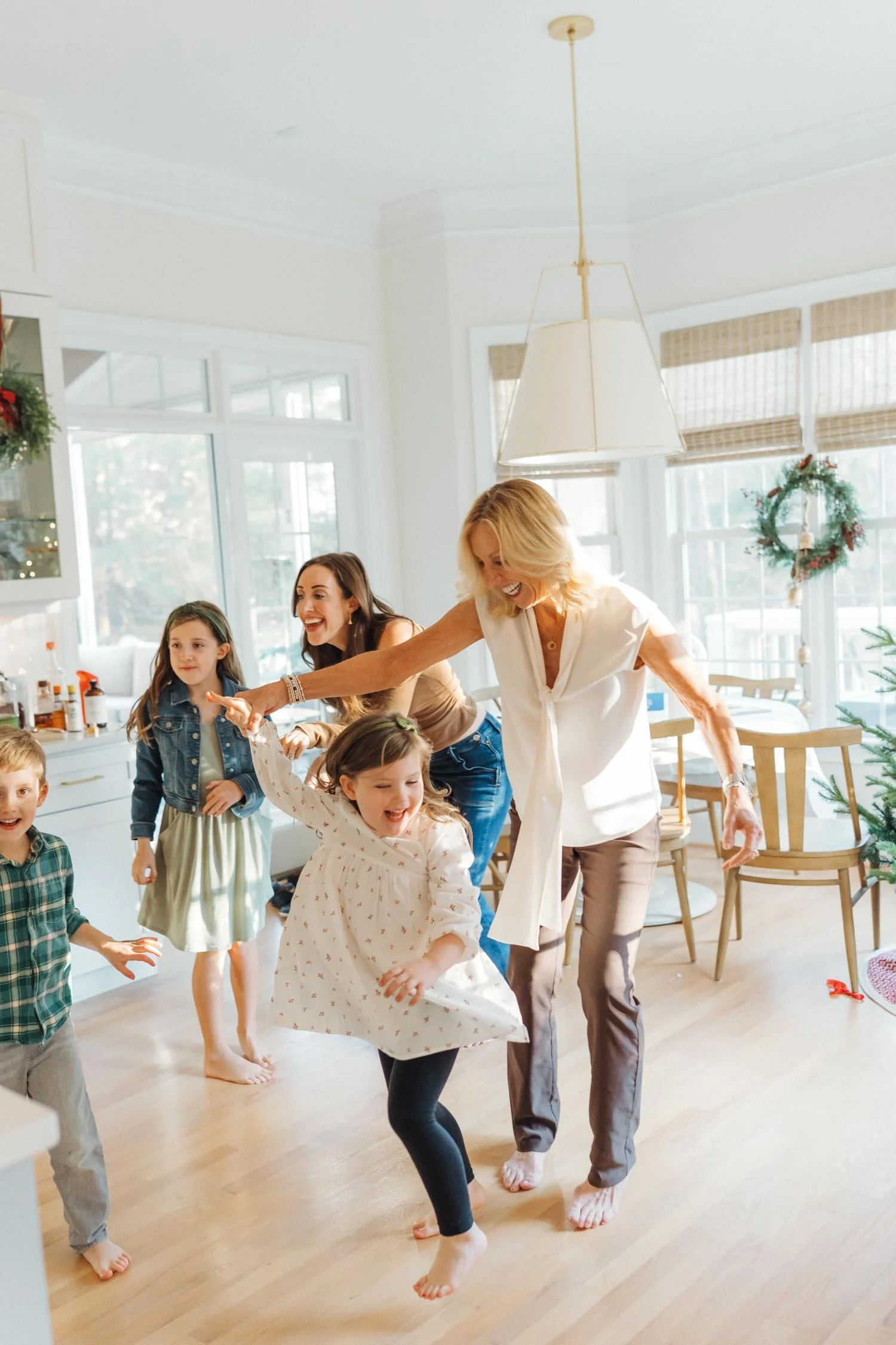 Large multi-generational family dancing together in the kitchen during a joyful family photography session by Autumn Brooke Photography.