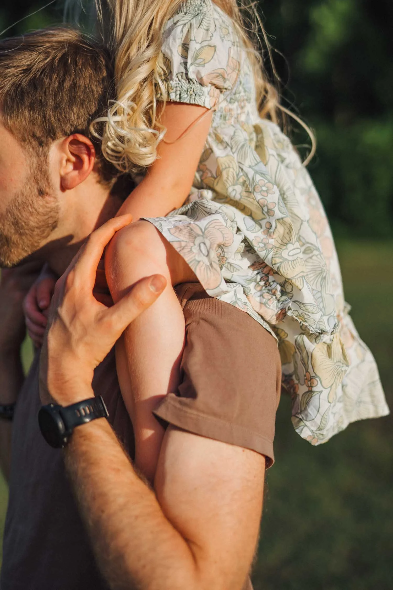 Close-up of a father holding his toddler on his shoulder during an outdoor family photography session in North Carolina.