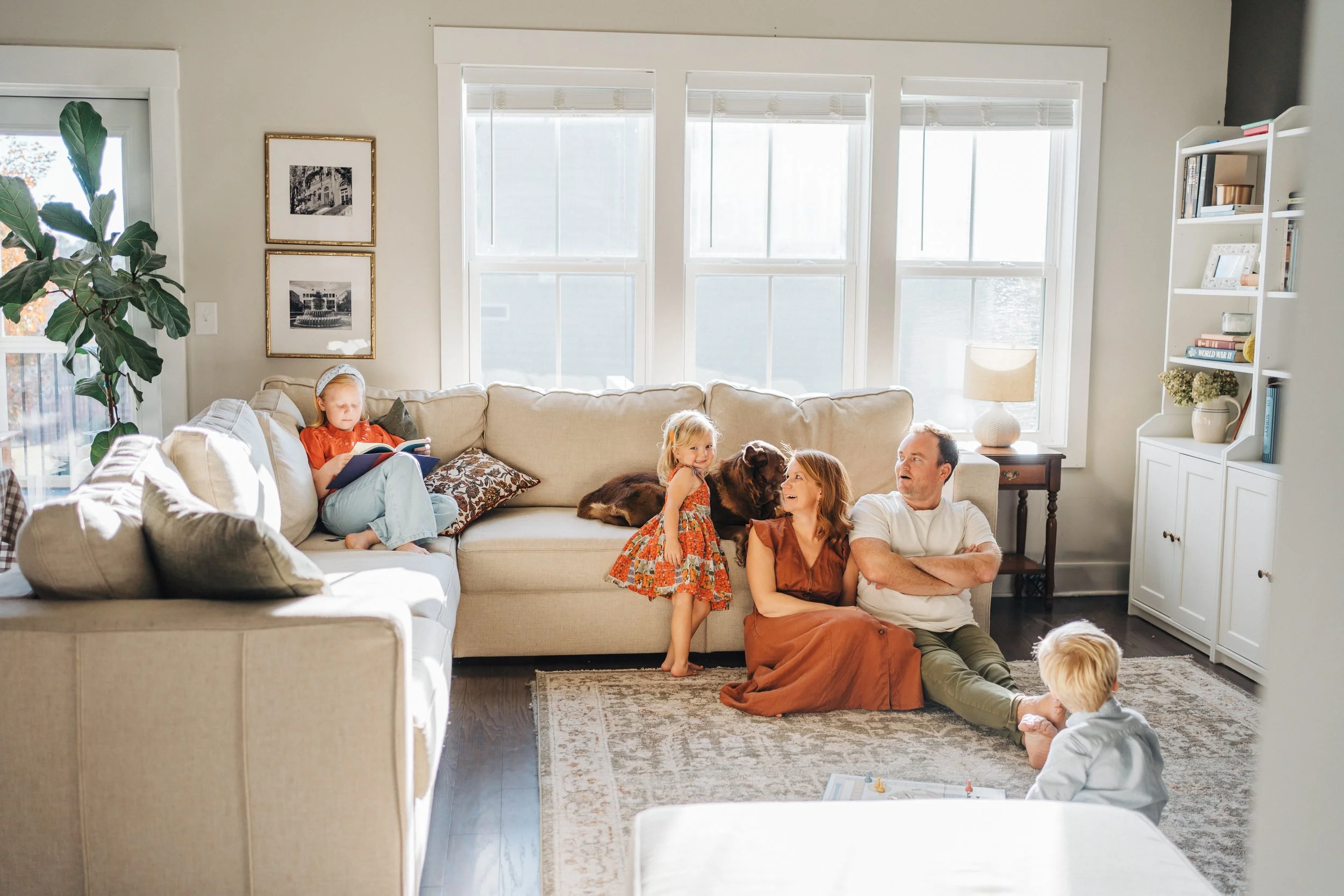 Family of five in living room laughing with natural light Raleigh Family Photographer