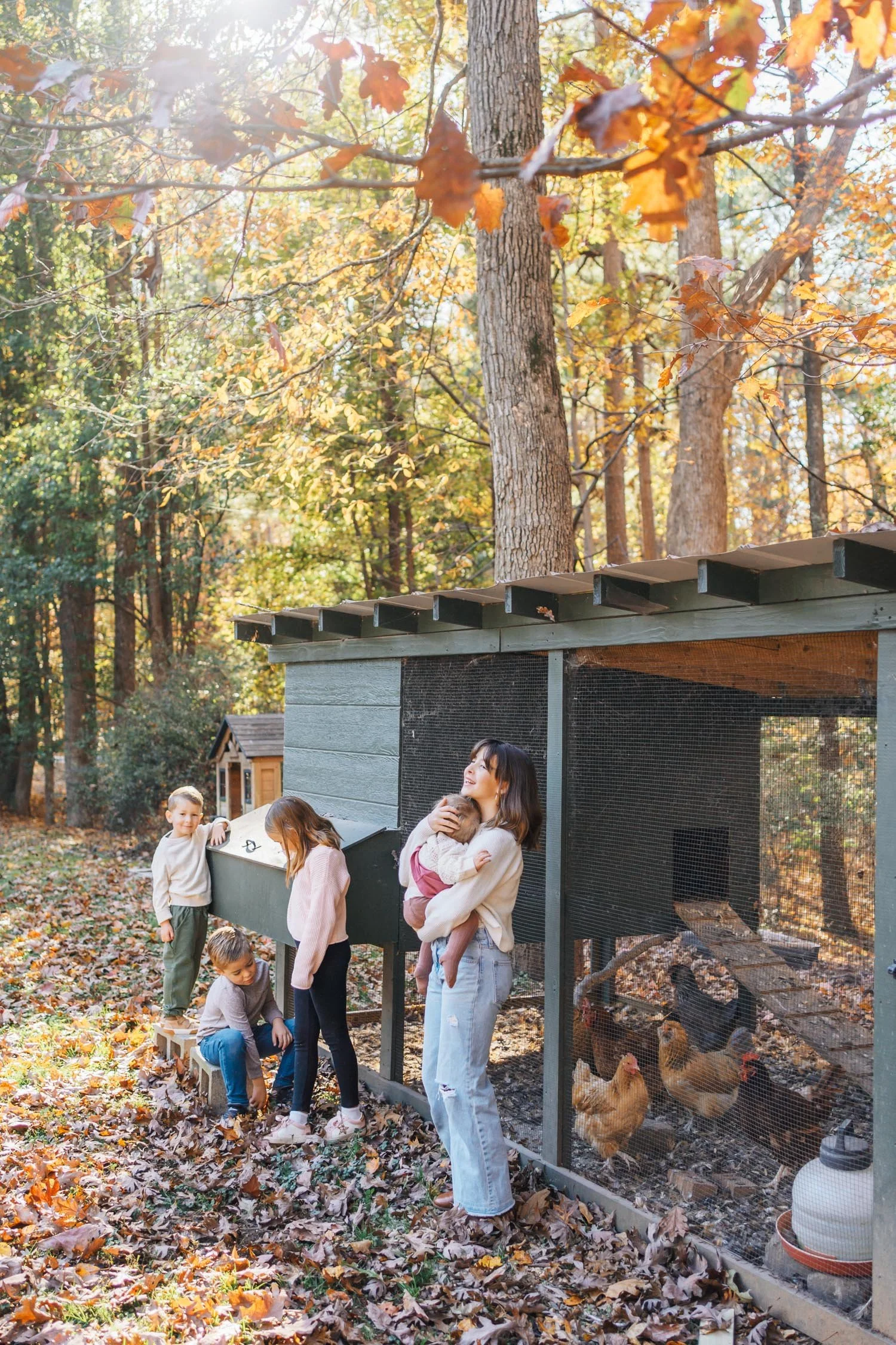 Family playing together outside near their chicken coop at home during an at-home family photography session in Raleigh–Durham.