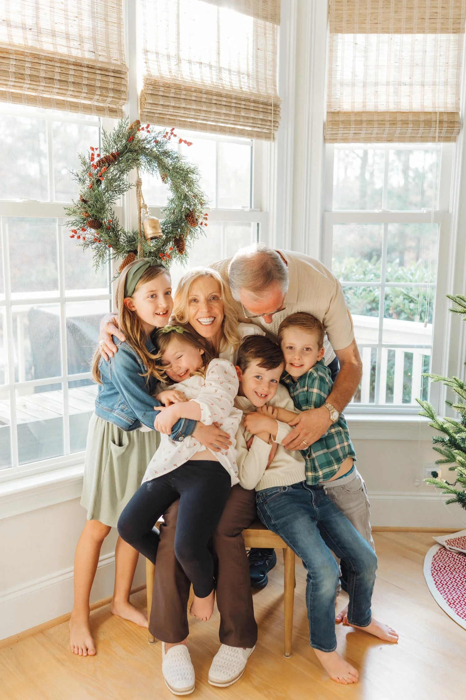 Grandparents embracing four grandchildren inside their home during a joyful multi-generational family photography session in Raleigh–Durham.