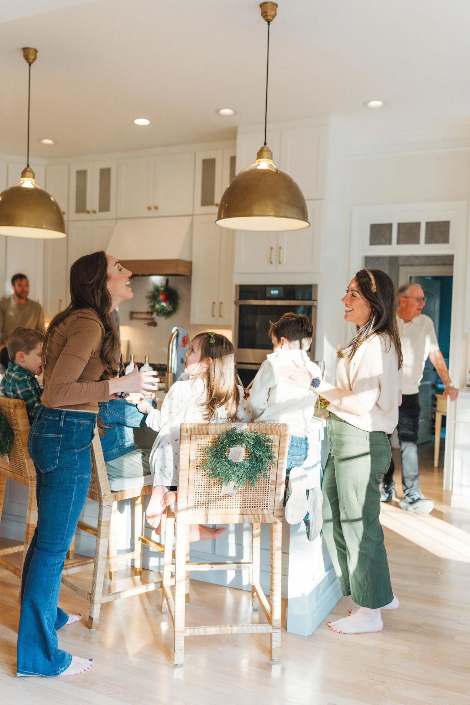 Parents talking together over the heads of children seated at a kitchen island during a holiday multi-generational family photography session in Raleigh, NC.