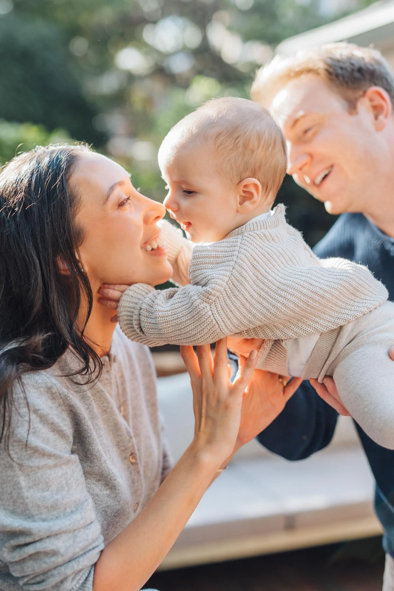 Mother holding her baby close and rubbing noses outdoors during a tender family photography moment in Raleigh, NC.