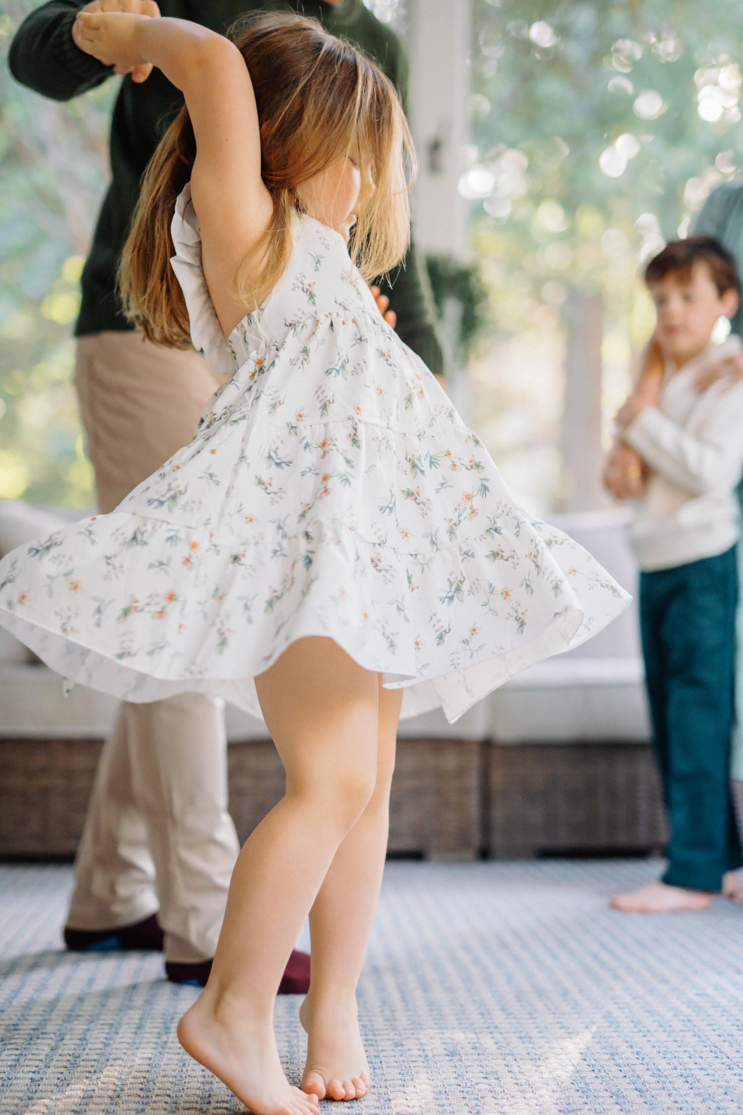 Toddler twirling in a dress inside her home during a candid family photography session by Autumn Brooke Photography in Raleigh, NC.