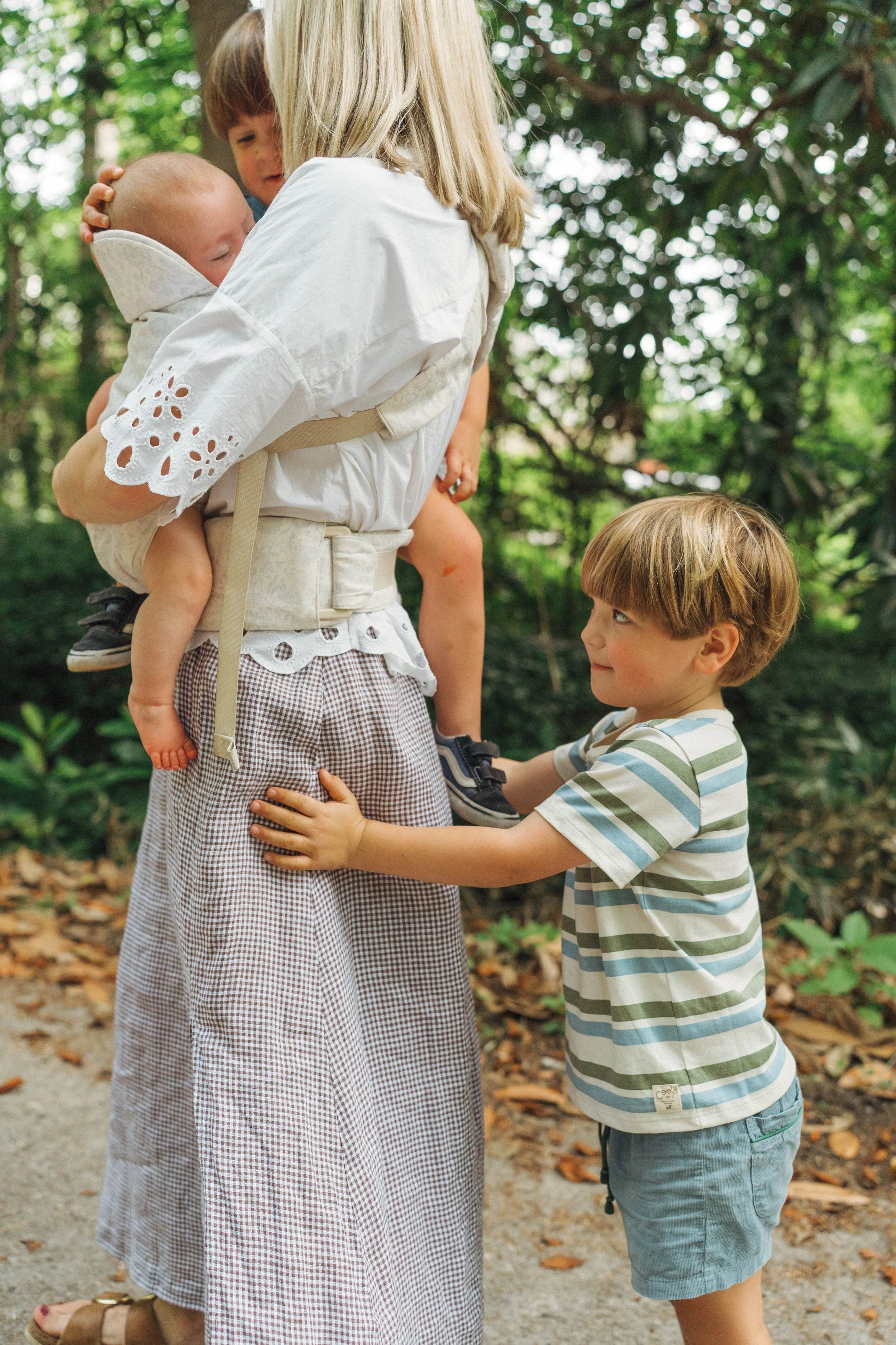 Close-up of a parent holding a baby outdoors at the park during a natural family photography session in Raleigh, North Carolina.