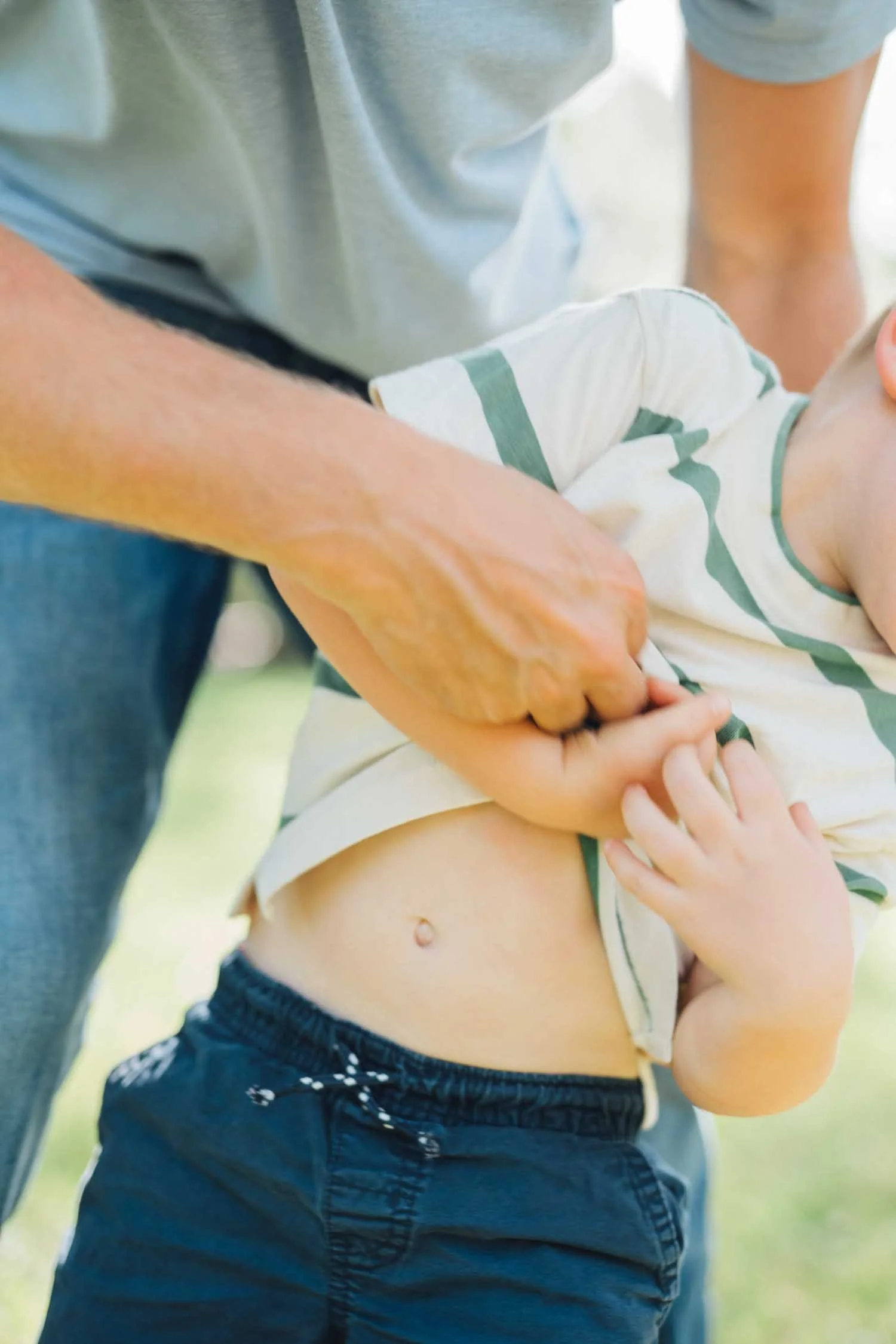 Father and son playing together outside during a natural family photography session in Raleigh, NC.