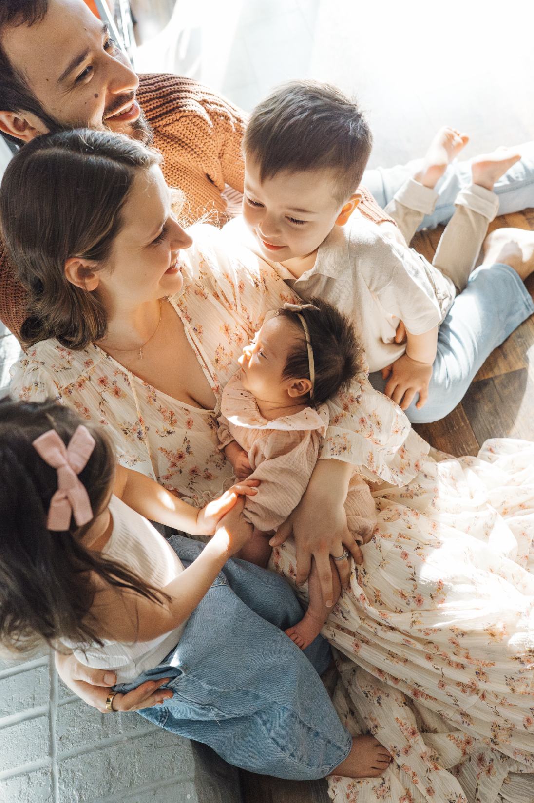 Family of five cuddled together with newborn for family photography in Raleigh North Carolina Home