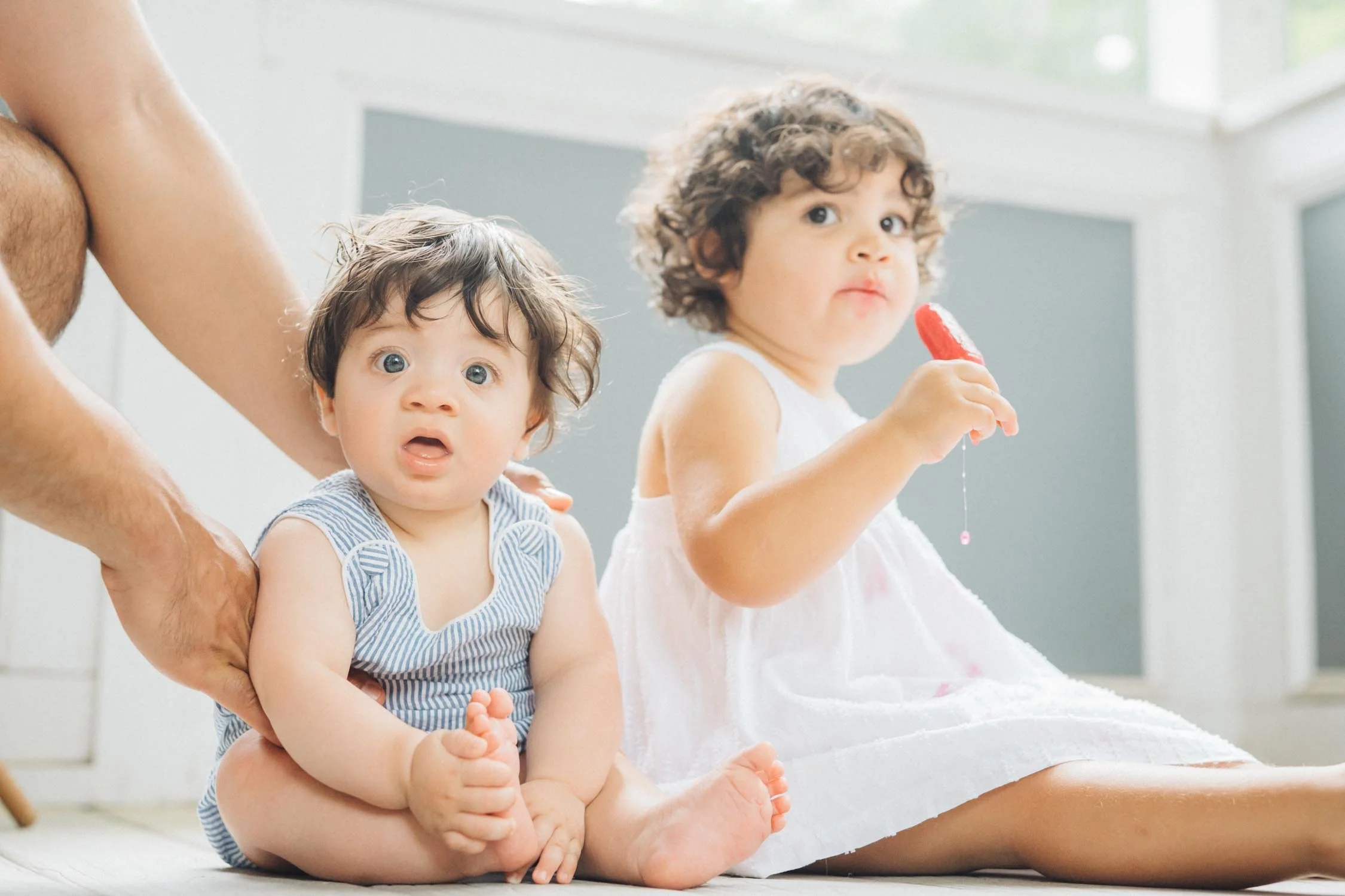 Two toddlers eating popsicles inside their home during a candid backyard family photography session by Autumn Brooke Photography.