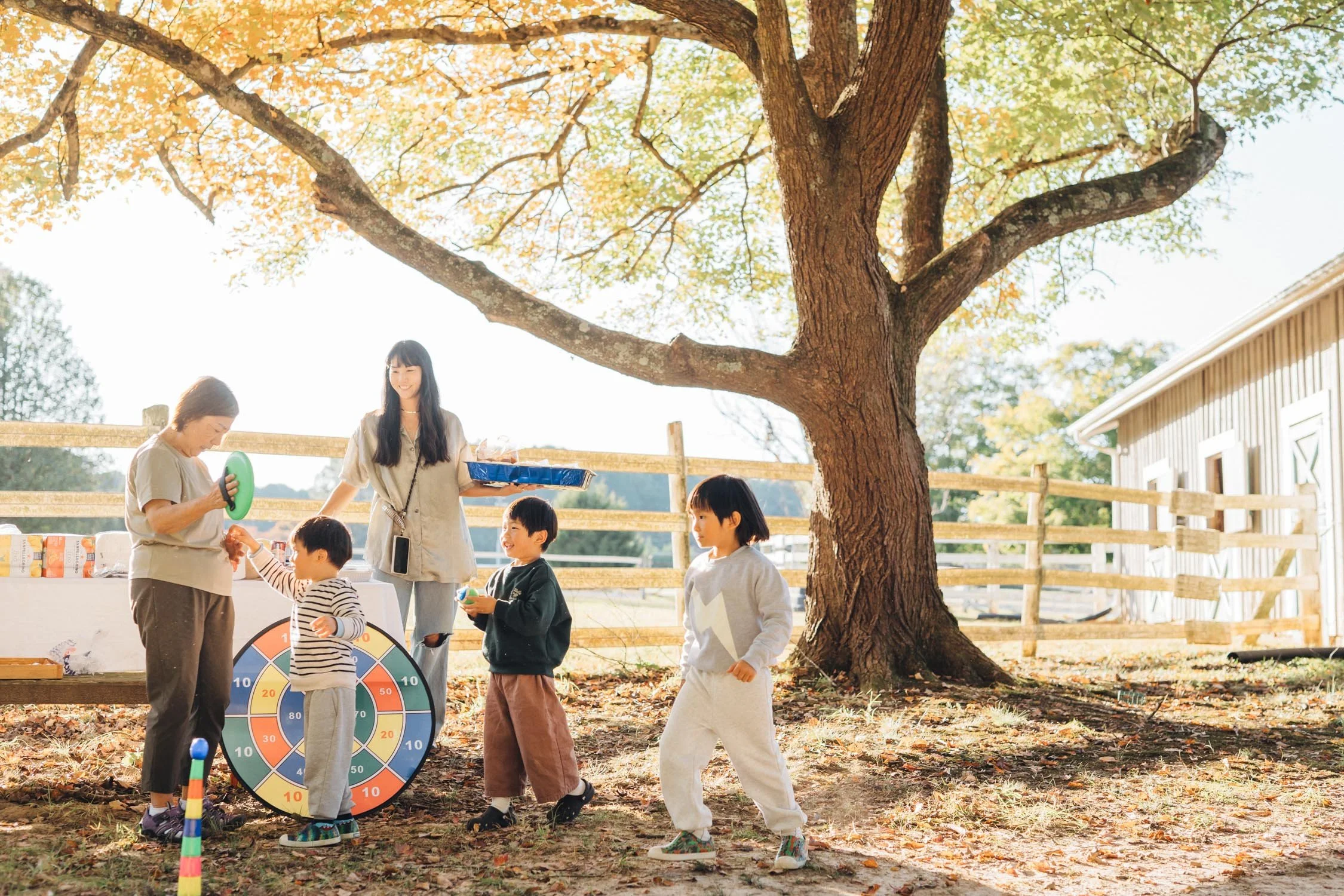 Family of multiple generations playing games with children in the backyard during a relaxed multi-generational family photography session in Raleigh–Durham.
