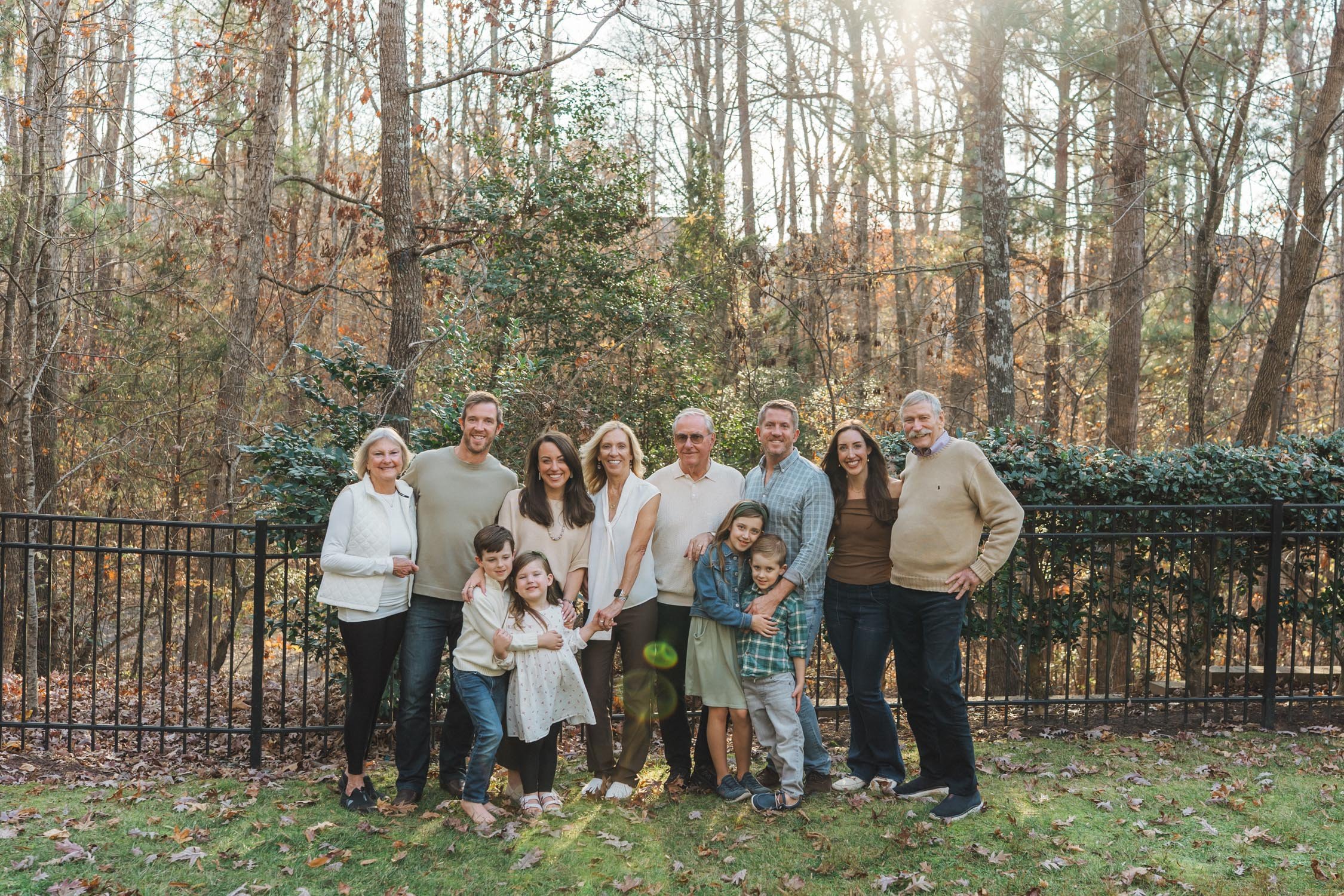 Large extended family posing together in the backyard during a multi-generational family photography session in Raleigh, North Carolina.