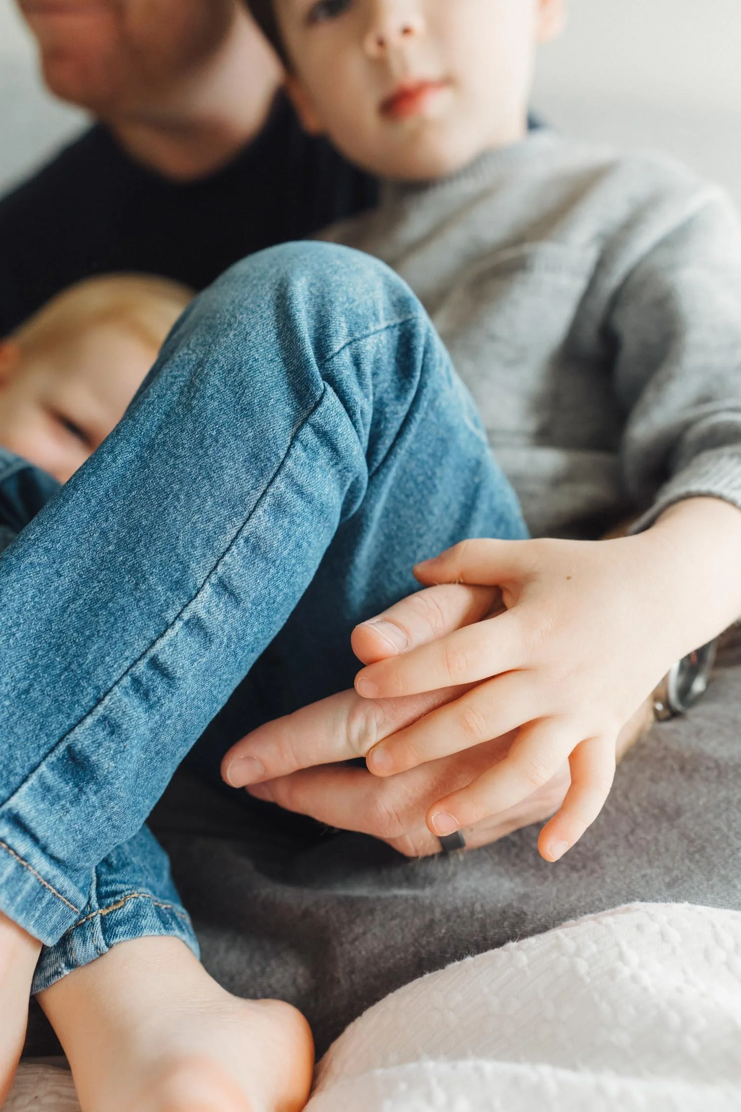 Close-up of a child’s hand intertwined with their father’s hand, representing presence during a family photography session in Raleigh, North Carolina.