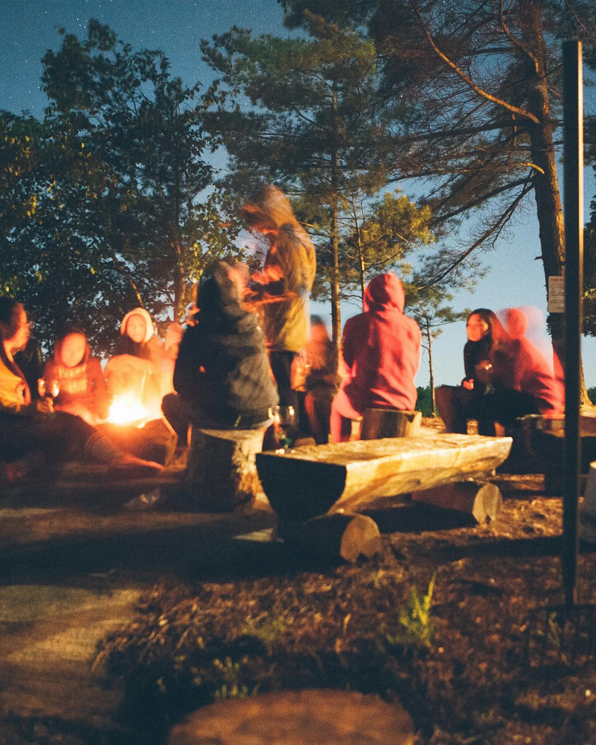 Group of people around a fire at a campsite