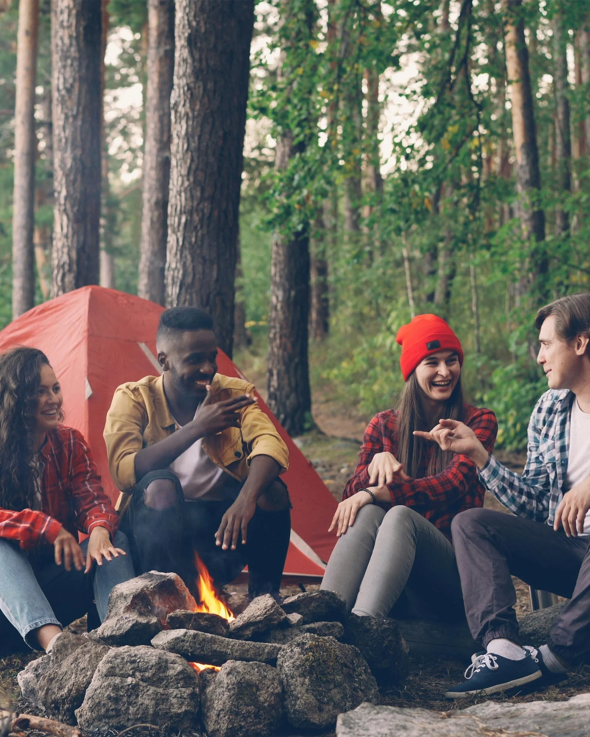 Group of friends talking around campfire