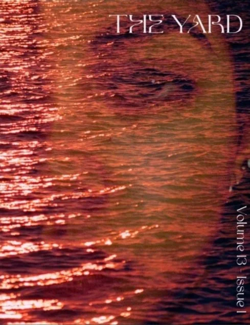 Photograph of a water surface reflecting a sunset or sunrise with orange and pink hues, with the words 'The Yard' written in the top right corner and 'Volume 13 | Issue' written vertically on the right side.