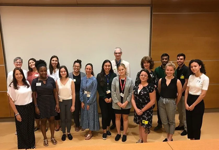 Group of diverse people posing for a photo in a conference room.