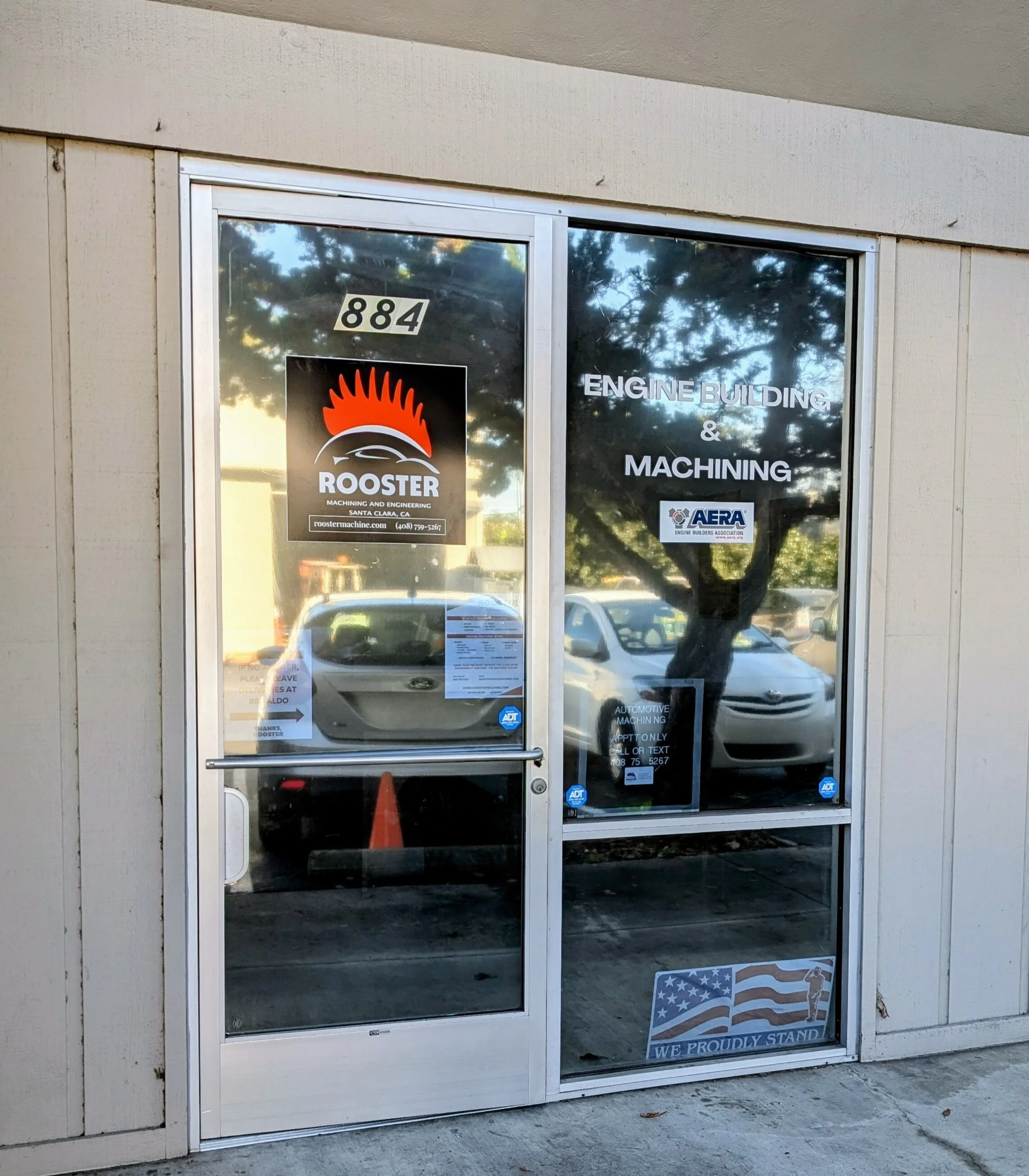 Front door of a business with signs for Rooster Machining and Engineering, and Engine Building & Machining. 