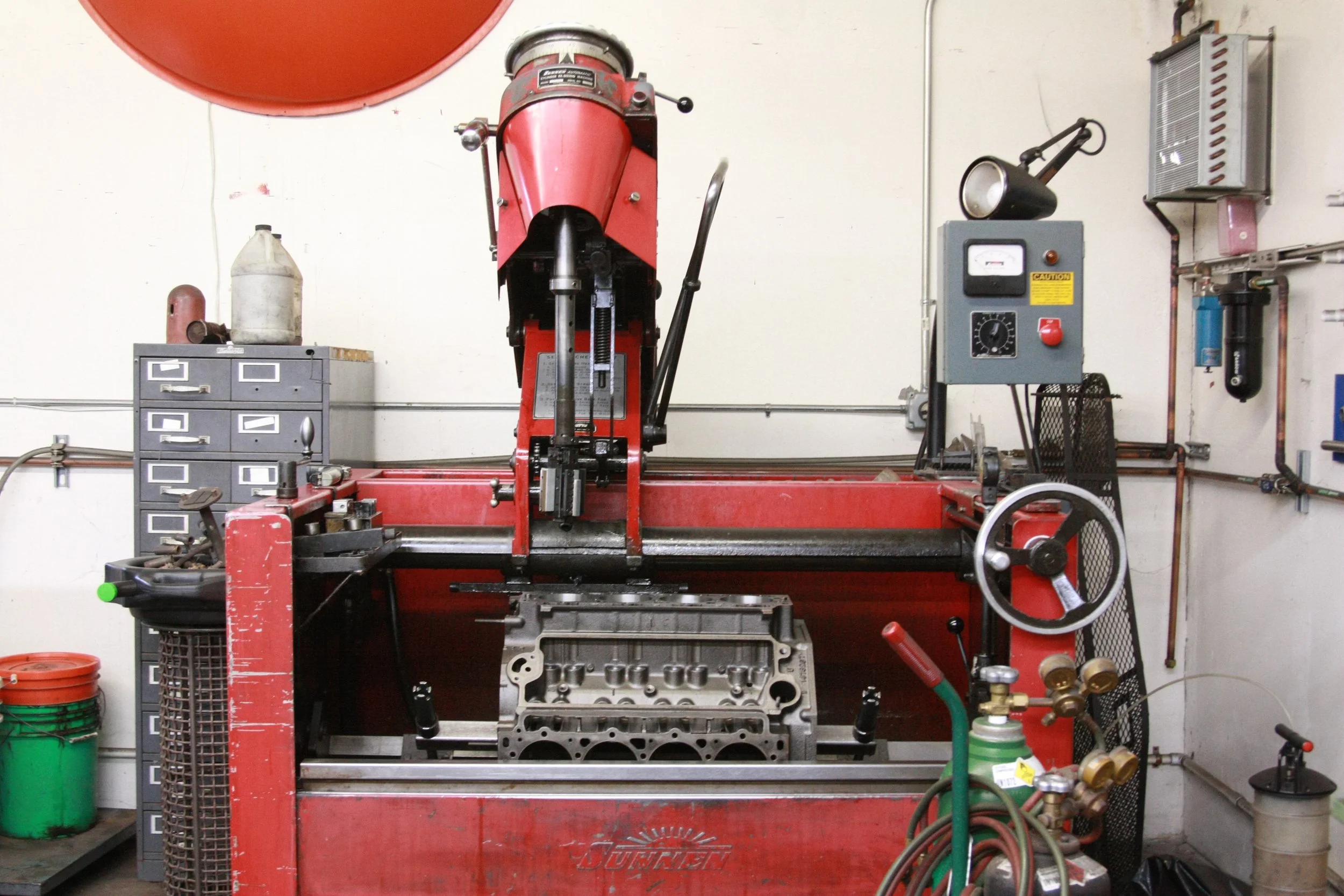 Sunnen Honing machine working on an engine block, in automotive machine shop.