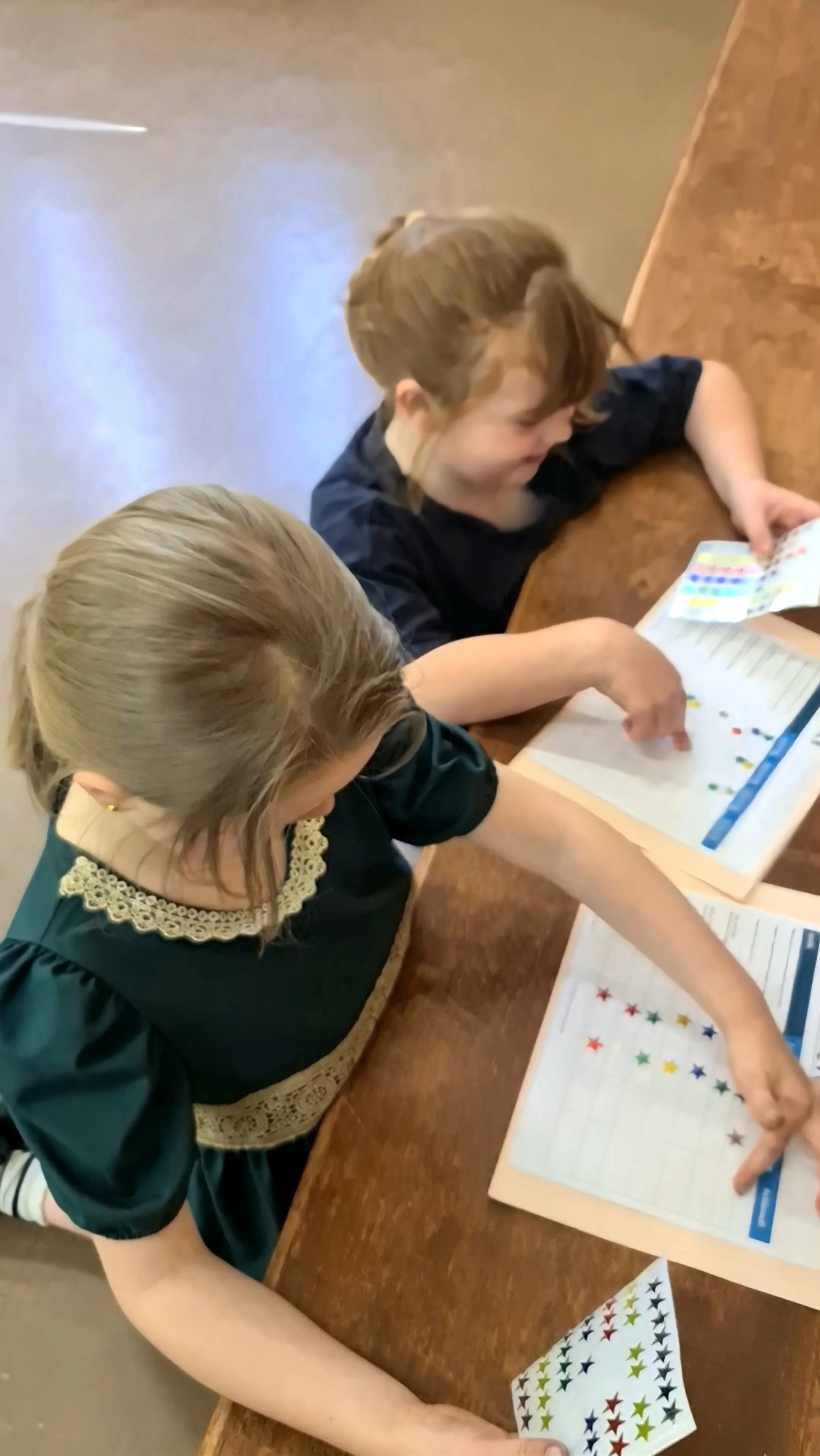 Students from Orange Academy of Irish Dance placing stickers on their progress charts, celebrating effort, achievement and personal milestones in a supportive learning environment in Orange, NSW.