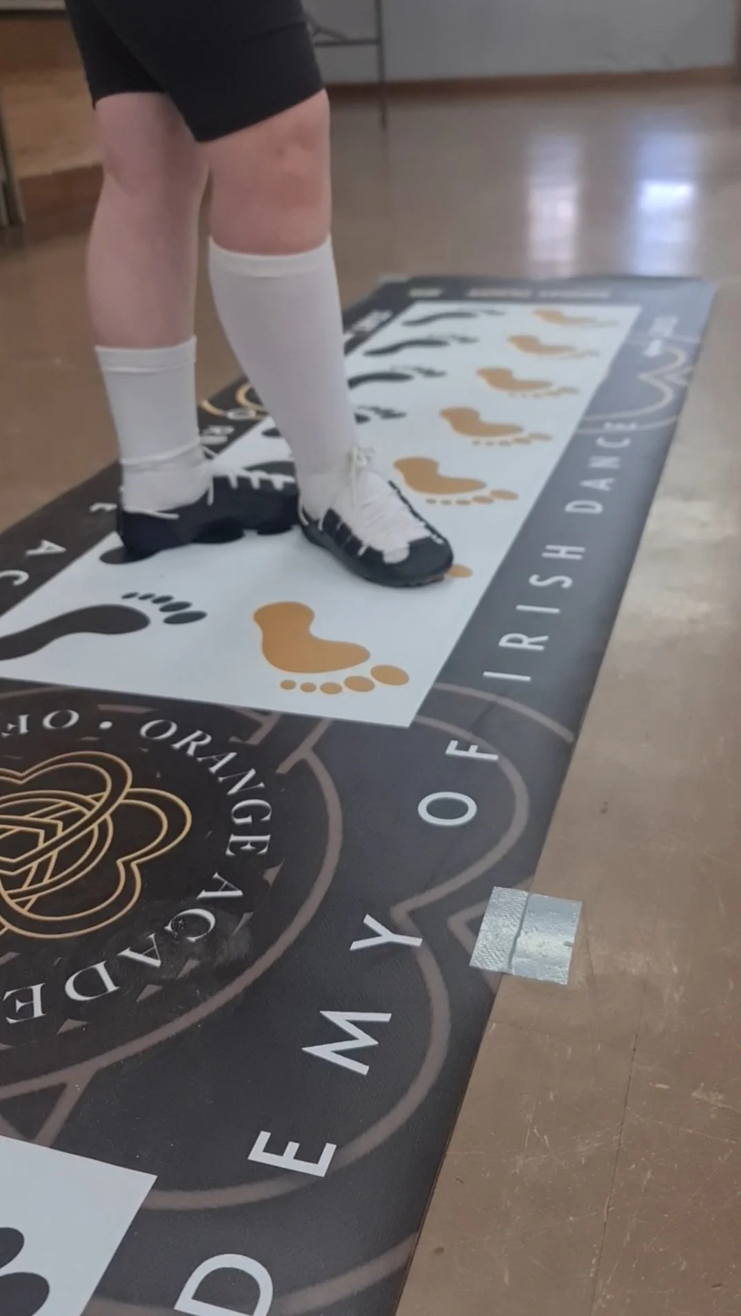 Student’s feet positioned on an Irish dance steps mat during class at Orange Academy of Irish Dance.
