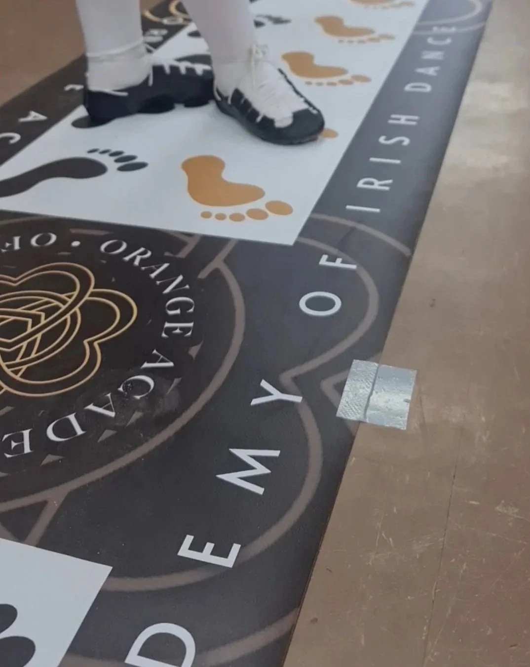 Close-up of a student’s feet on the Orange Academy of Irish Dance steps mat.
