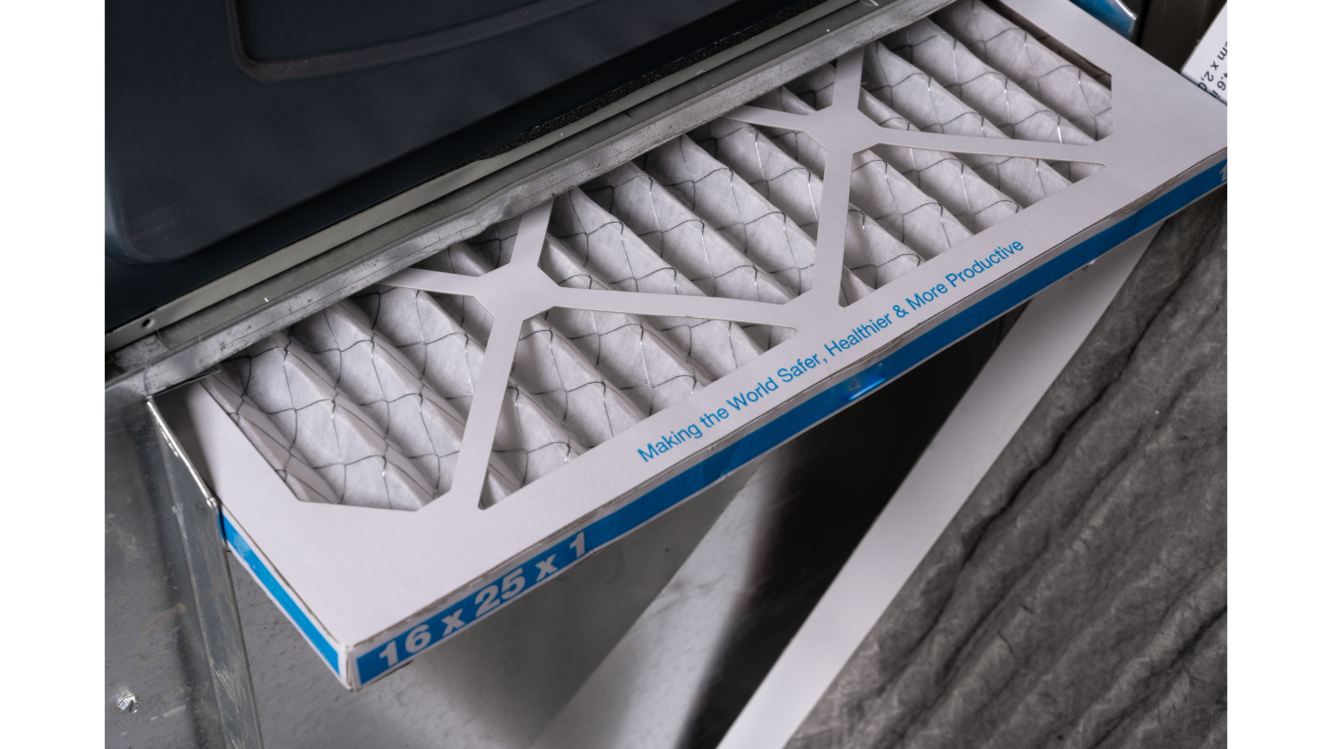 Close-up of a disinfectant wipe dispenser with wipes inside and a label that reads '16 x 25 x 1'. The box has a slogan on it that says 'Making the World Safer, Healthier & More Productive'.