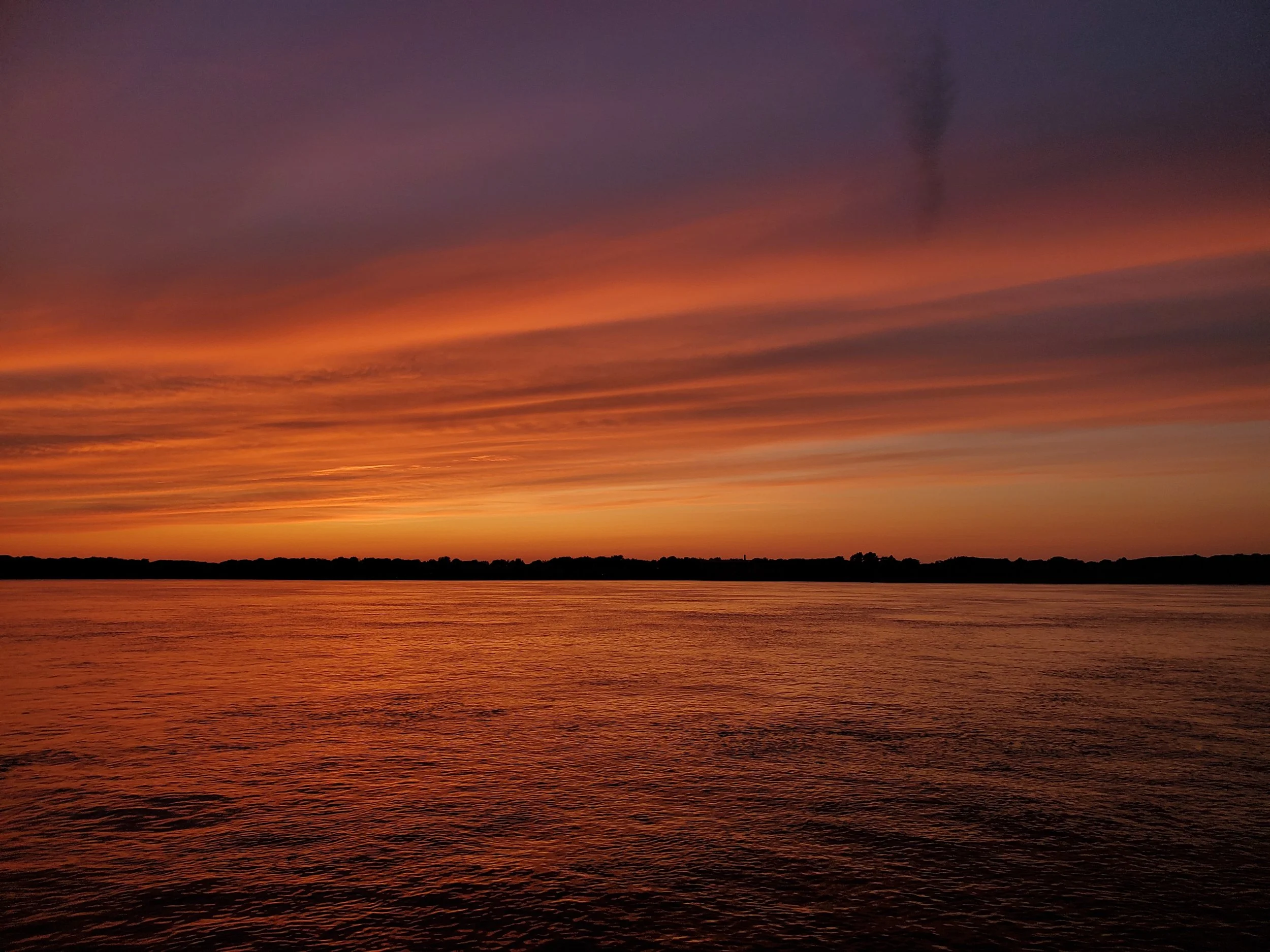 Sunset over Greenport waters with Sail Selina NY yacht, reflecting on the calm bay near Shelter Island, New York