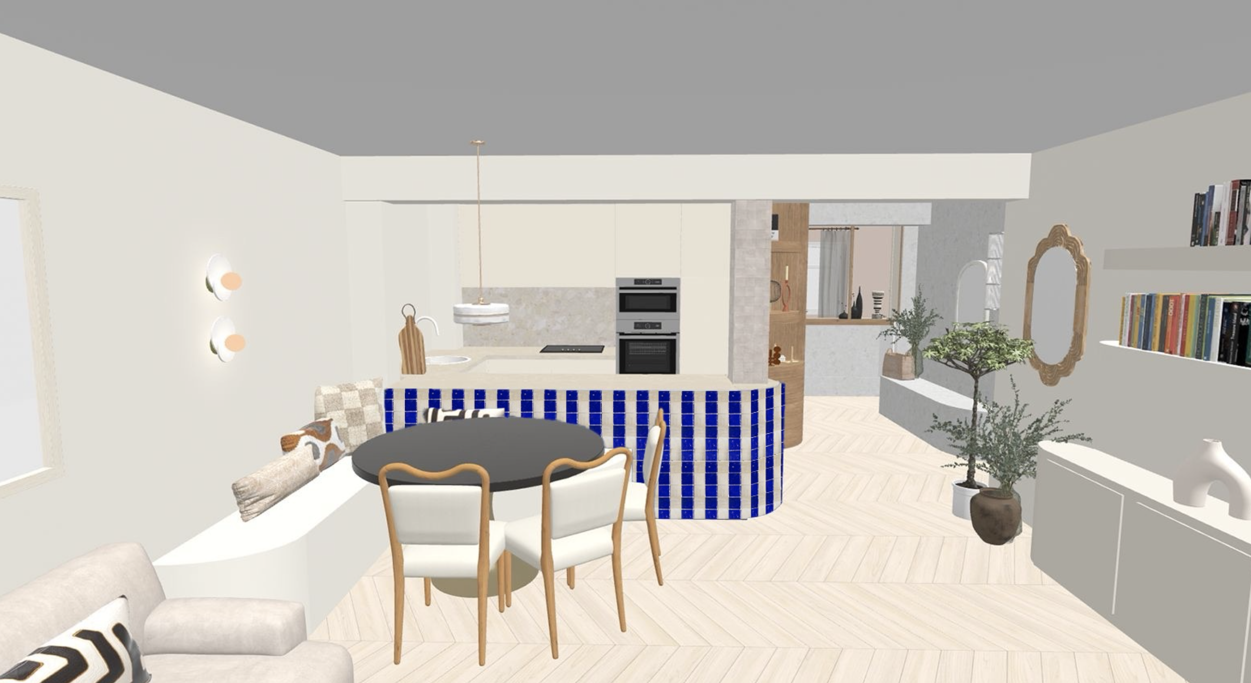 Modern open-concept living room and kitchen with dining area, featuring a round black table with cream-colored chairs, decorative pillows, green potted plants, built-in shelves with books, and white cabinets in the kitchen.