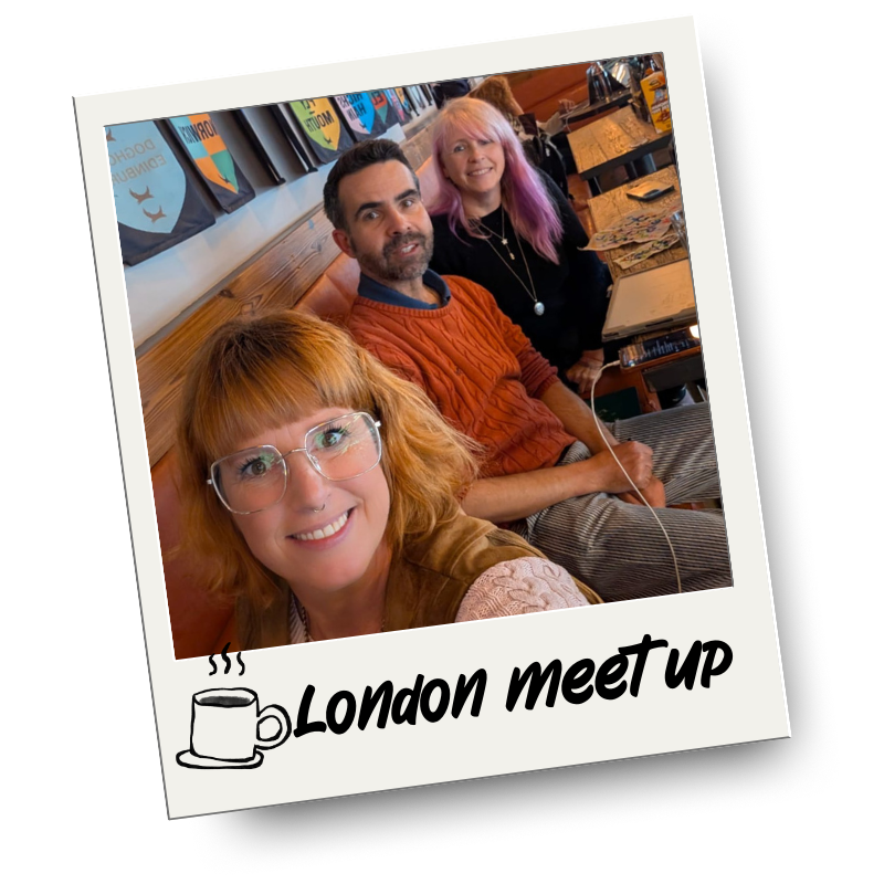 Three people sitting at a table in a cafe or restaurant, smiling for a selfie. The photo has a polaroid style with the text "London meet up" and a coffee mug icon at the bottom.