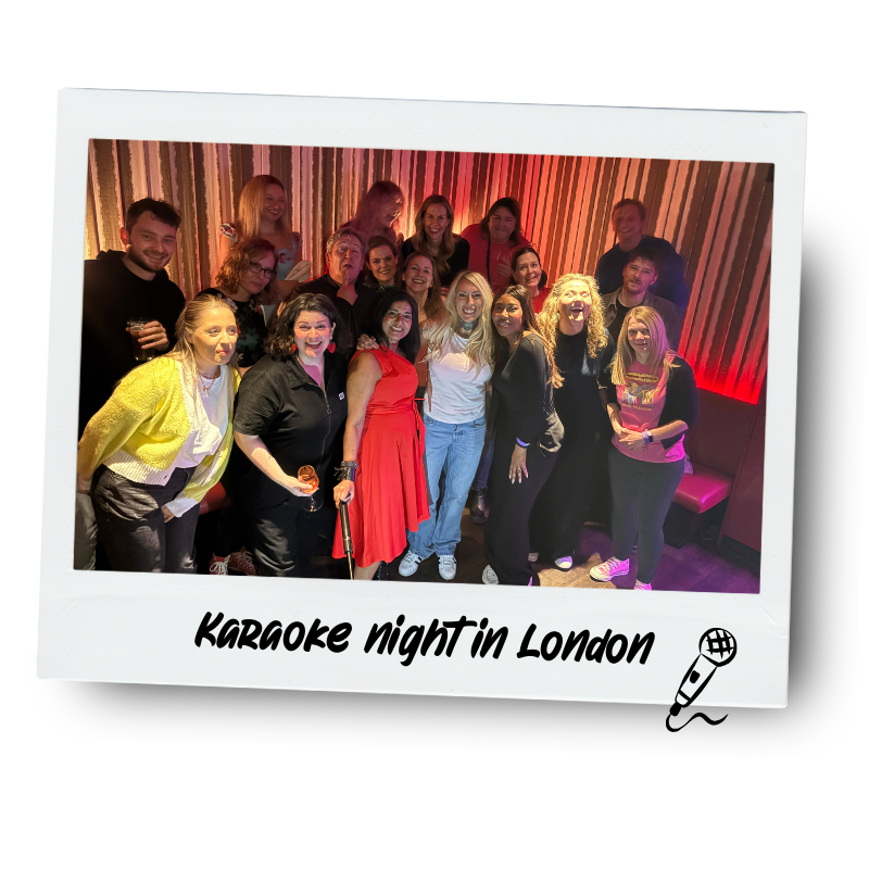 A group of people smiling and posing for a photo in a karaoke bar in London, with a colorful striped wall in the background. The photo has a white border with the text 'Karaoke night in London' and a small microphone icon.